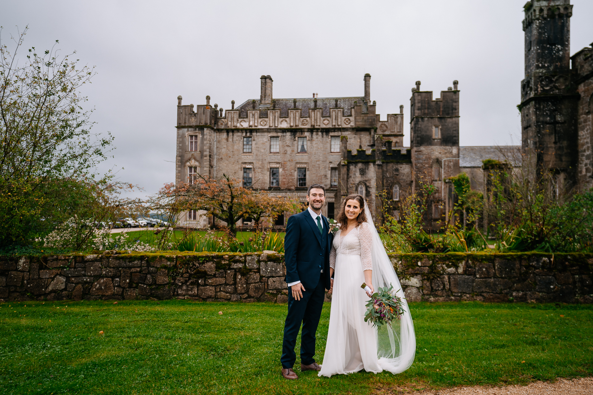 A man and woman posing in front of a castle