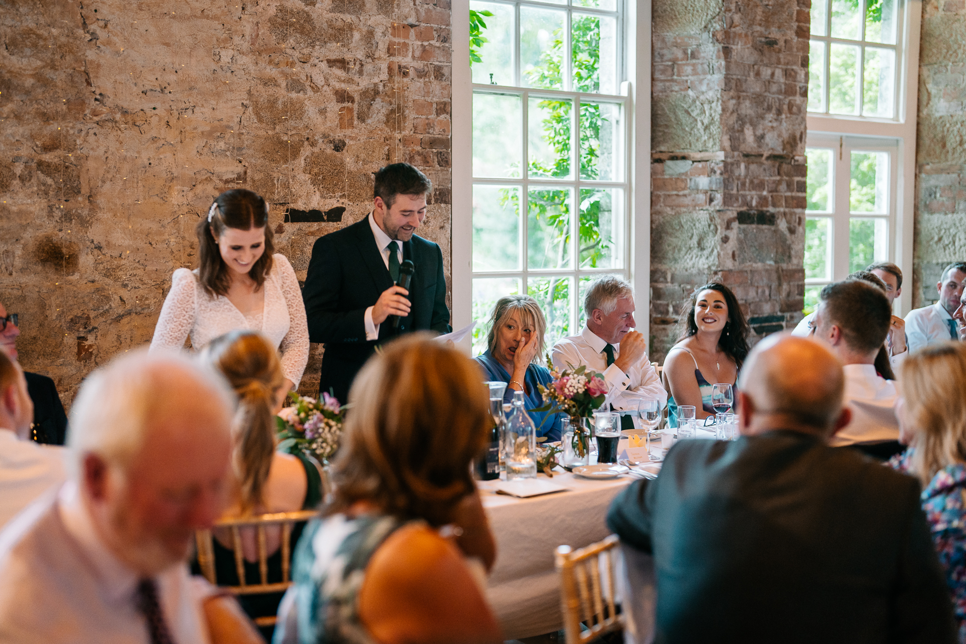 A person speaking to a group of people at a table