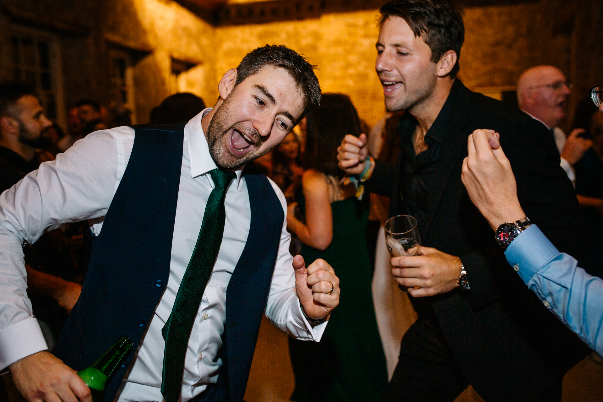 A couple of men laughing and holding glasses of wine