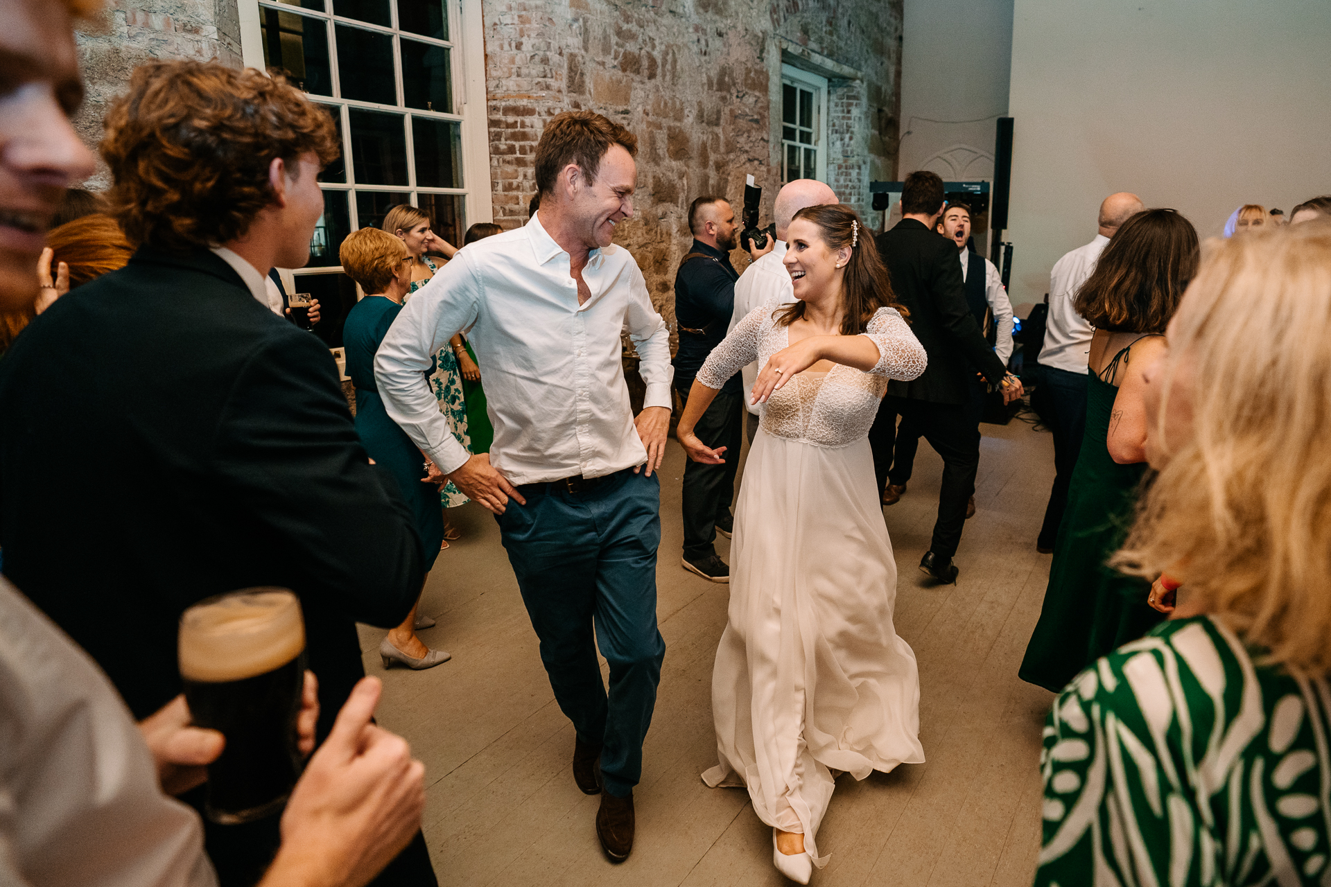 A man and woman dancing in a room full of people