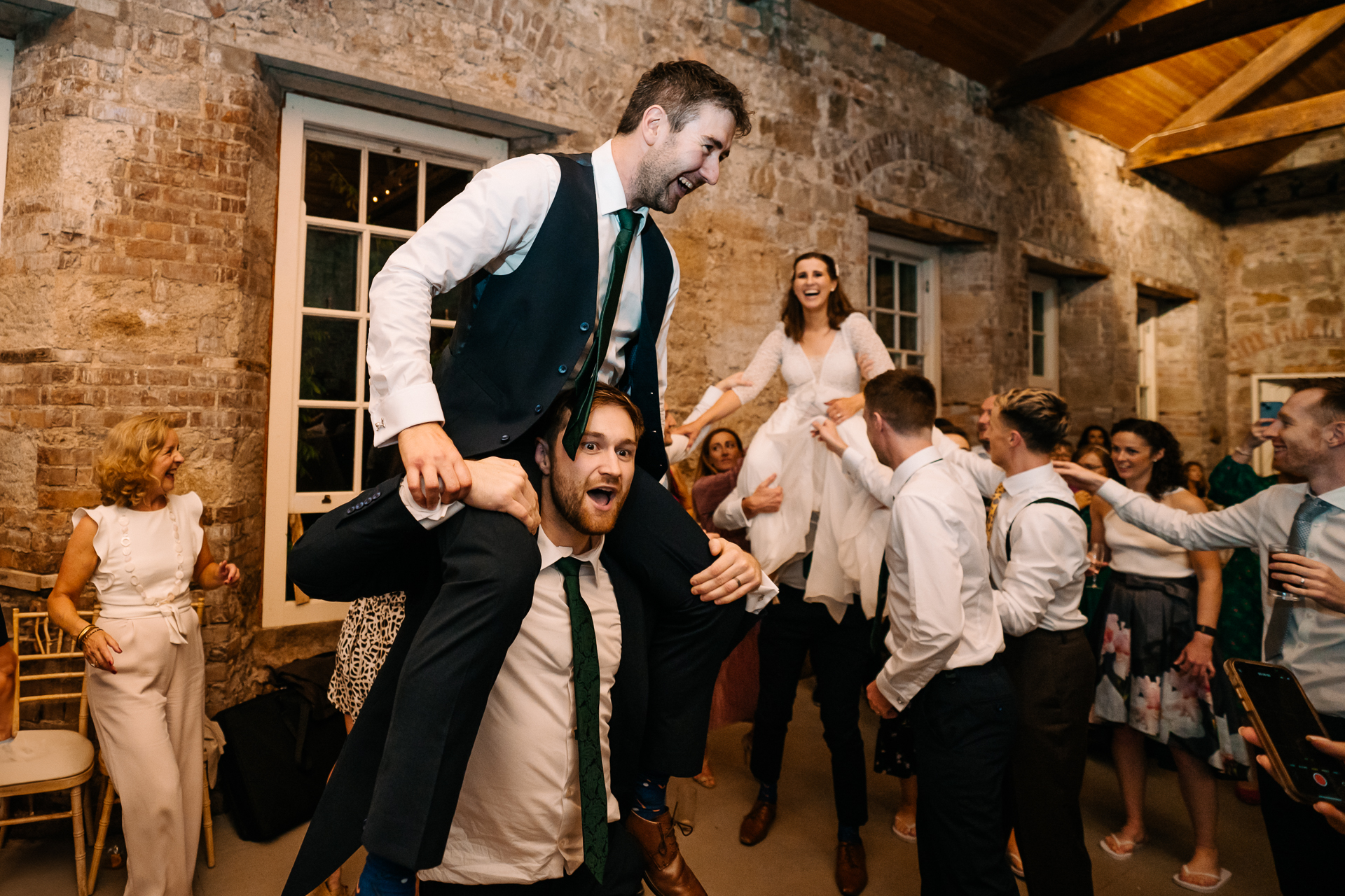 A man in a suit and tie dancing with a group of people