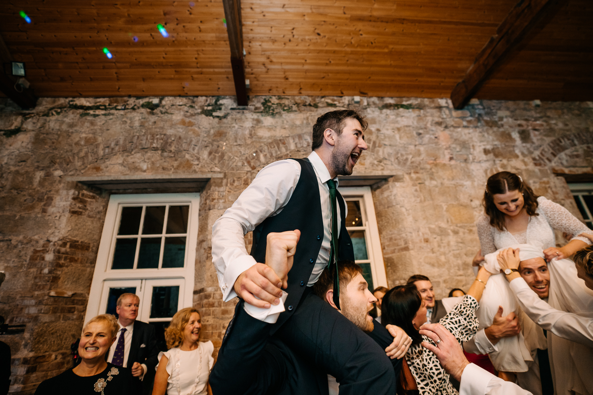 A person holding another man's hand in front of a crowd