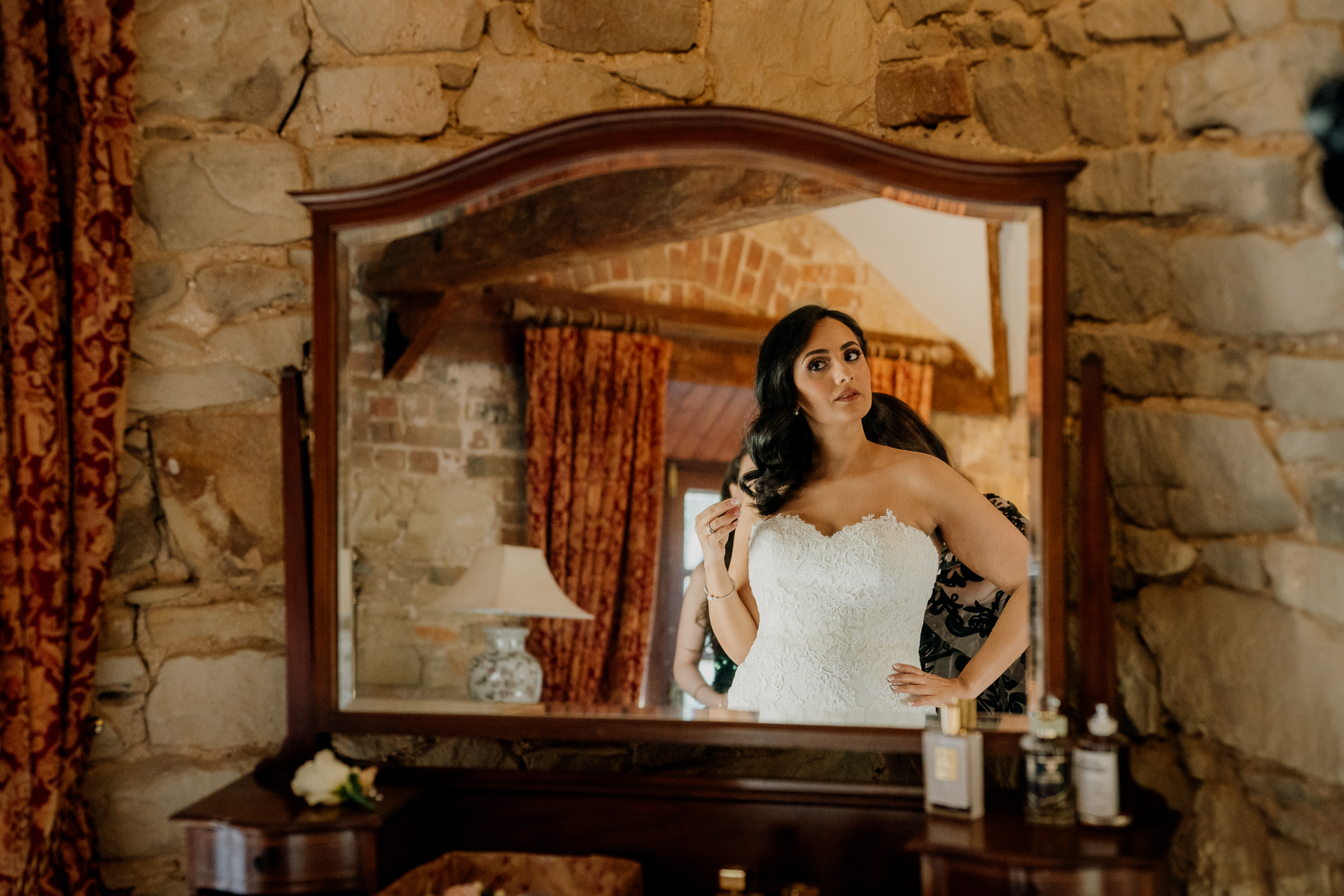 A person in a white dress in a room with a fireplace