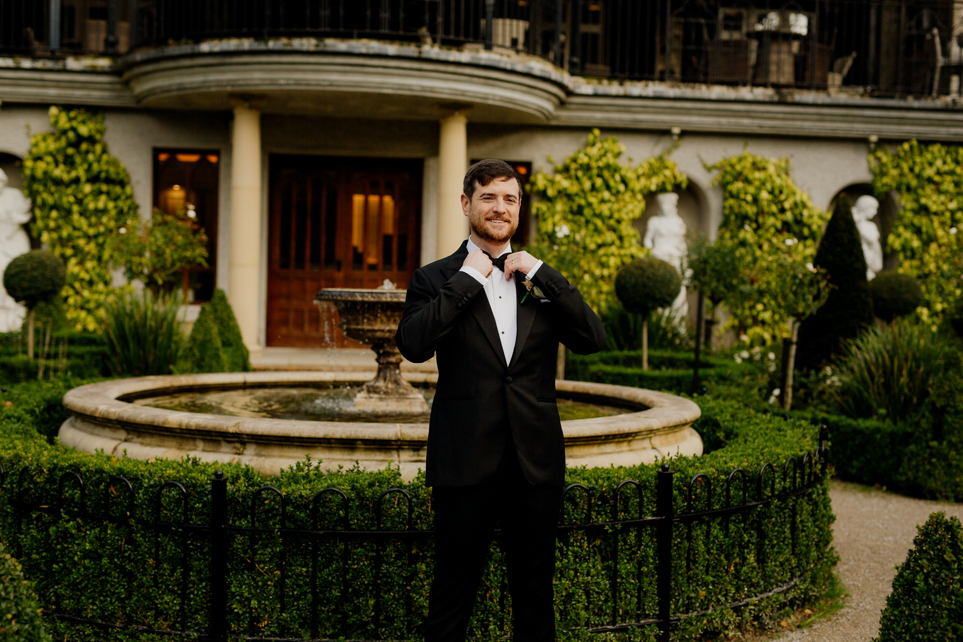 A man in a suit standing in front of a building