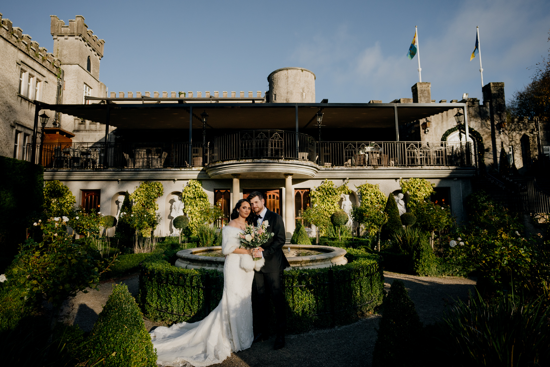 A man and woman in wedding attire standing in front of a building