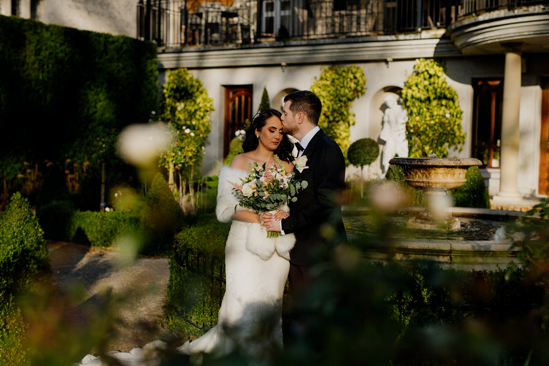 A man and woman posing for a picture in front of a fountain