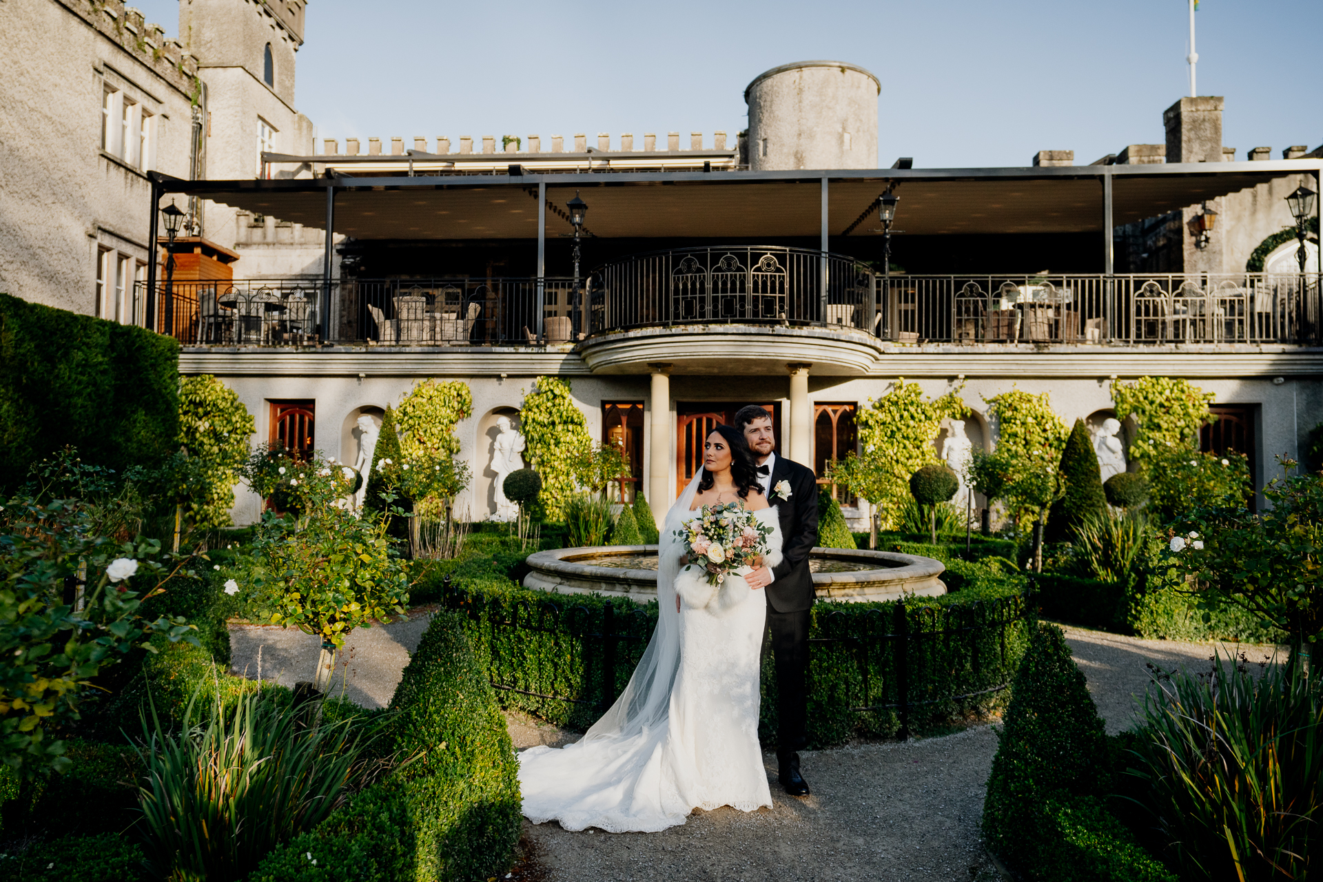 A man and woman in wedding attire standing in front of a building