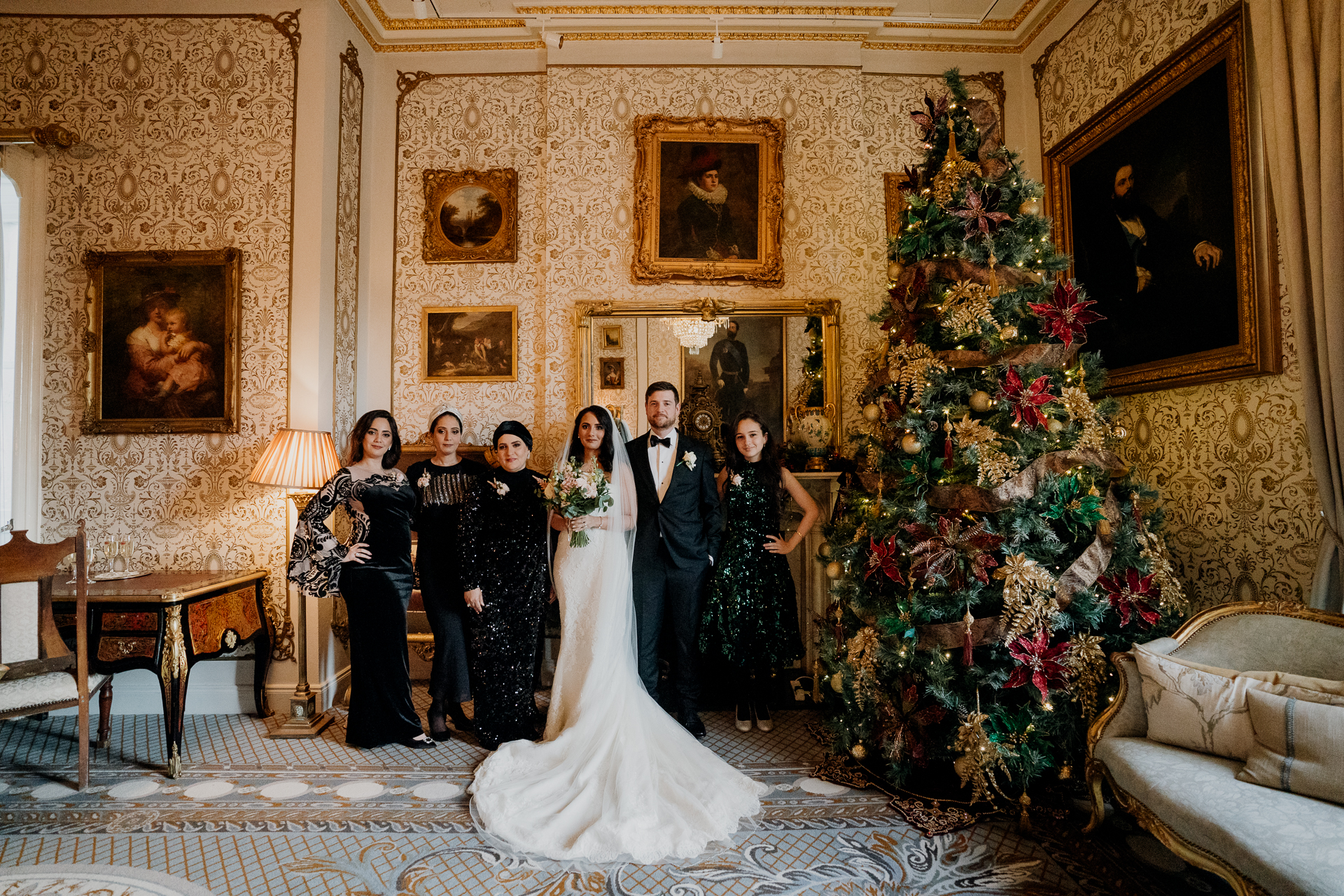 A group of people posing for a photo in front of a christmas tree