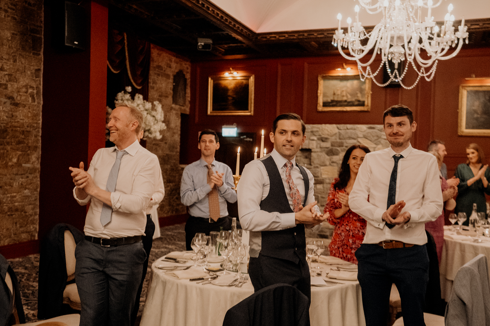 A group of people standing in a room with tables and chairs