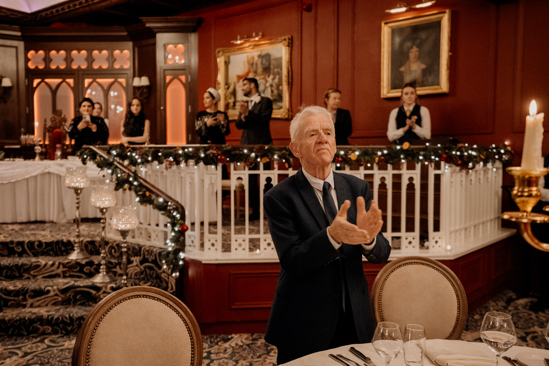 A person in a suit sitting at a table with a group of people