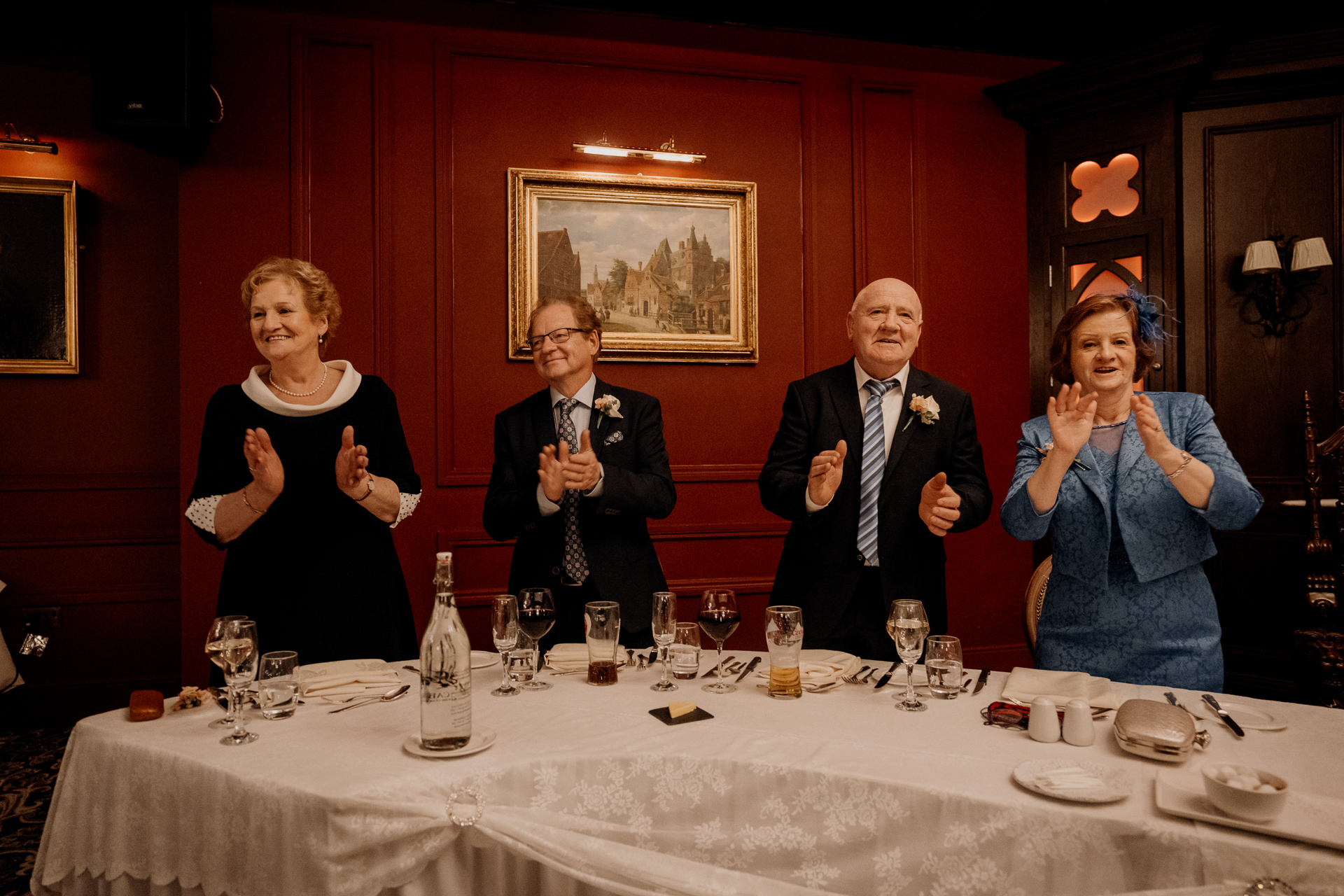 A group of people standing around a table with wine glasses