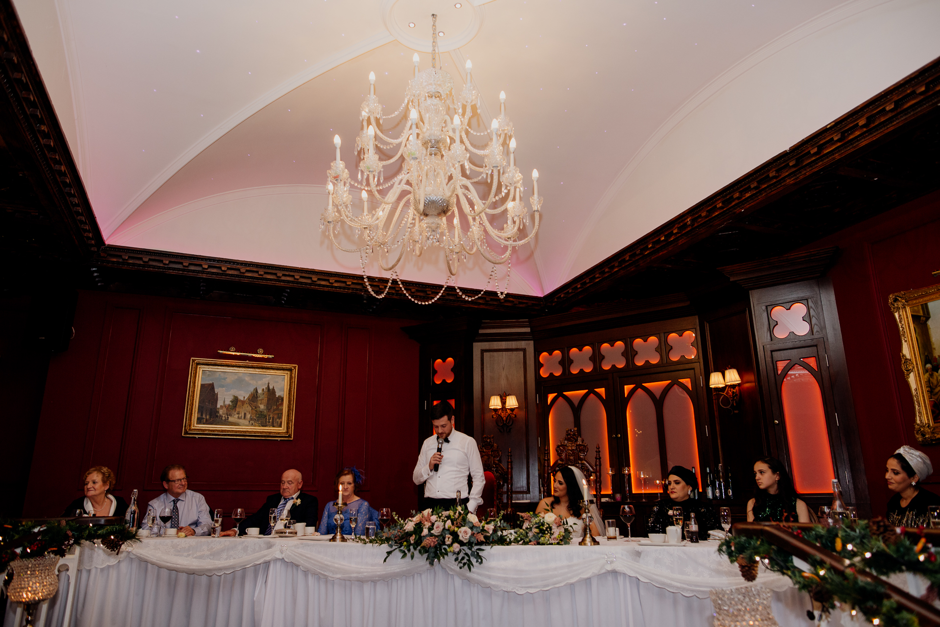 A group of people sitting at a table with a chandelier