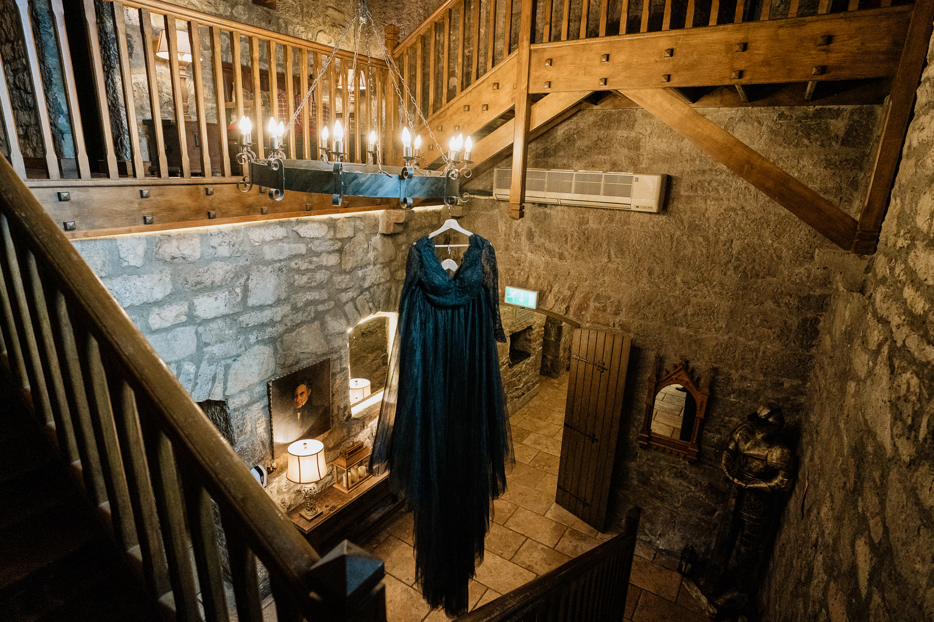 A room with a wood staircase and a blue robe from the ceiling