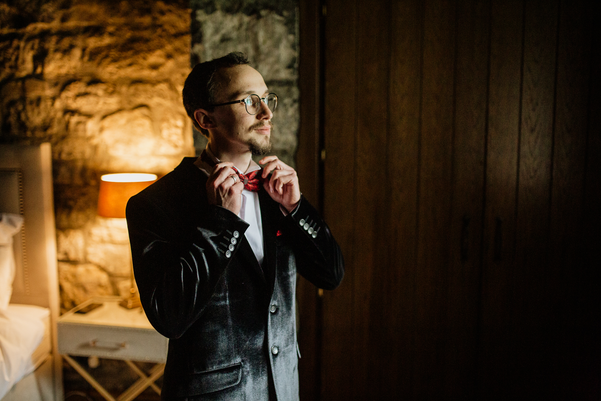 A man in a suit tying his tie