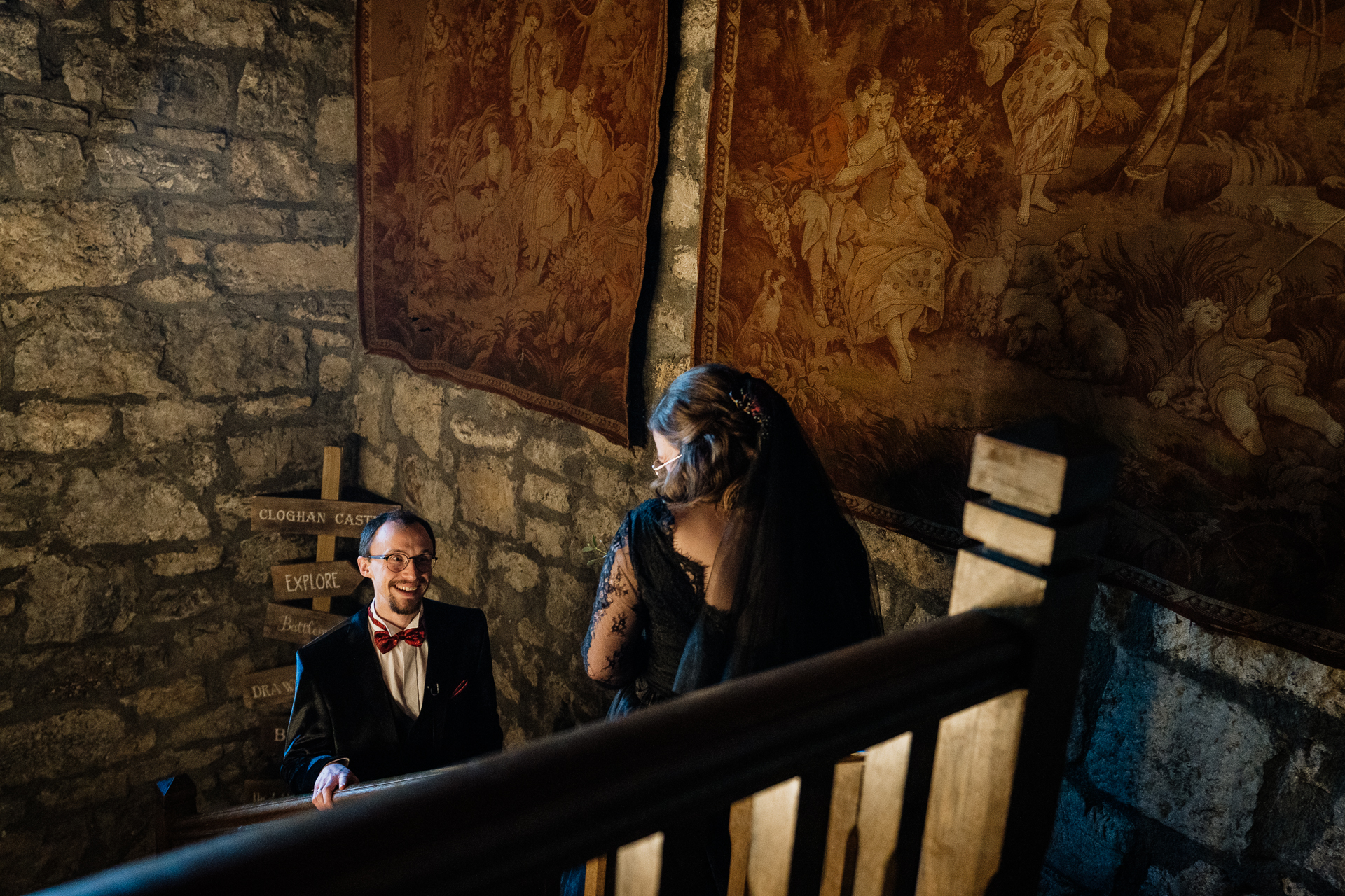 A man and woman standing on a staircase in a stone building