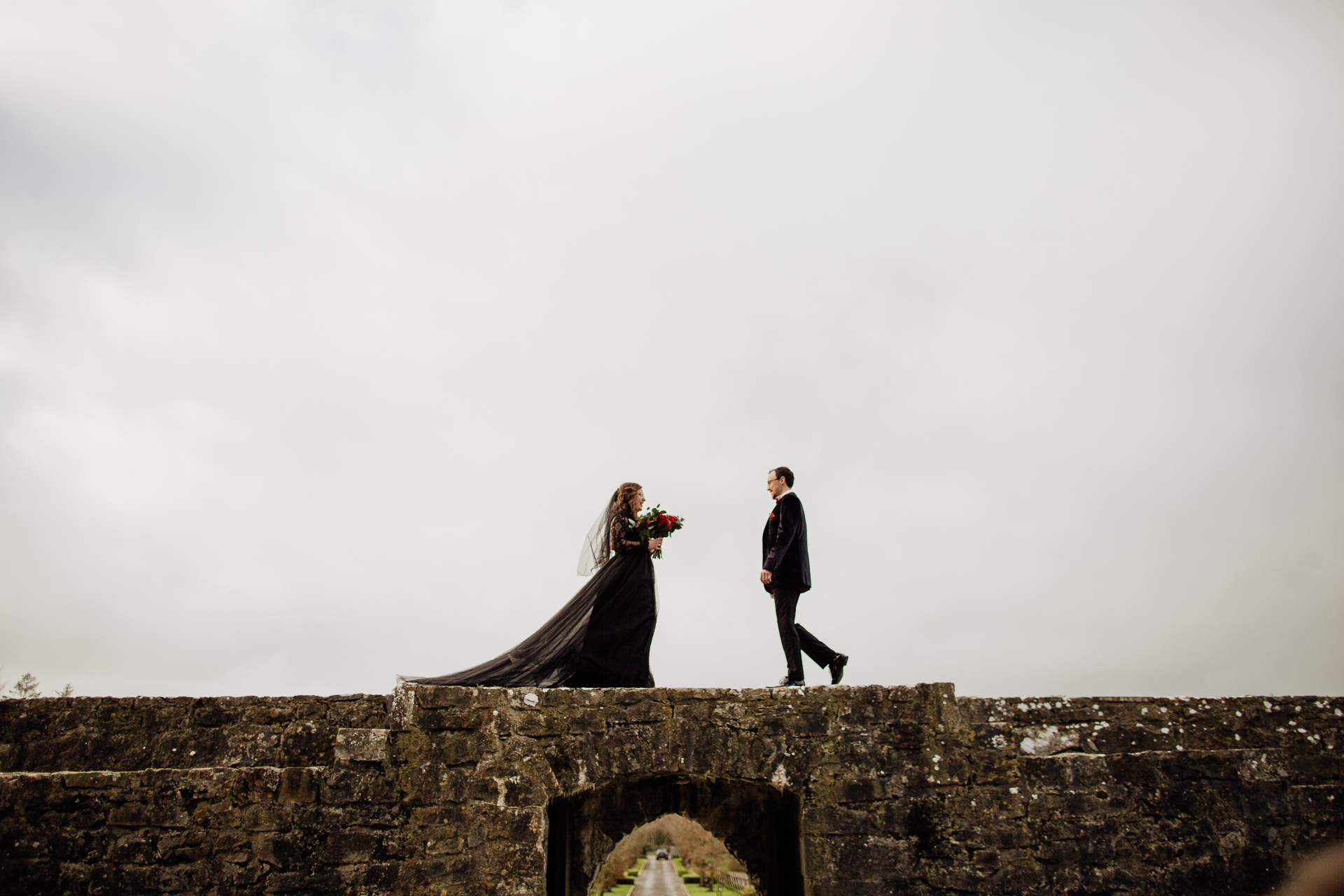 A man and woman walking on a stone wall