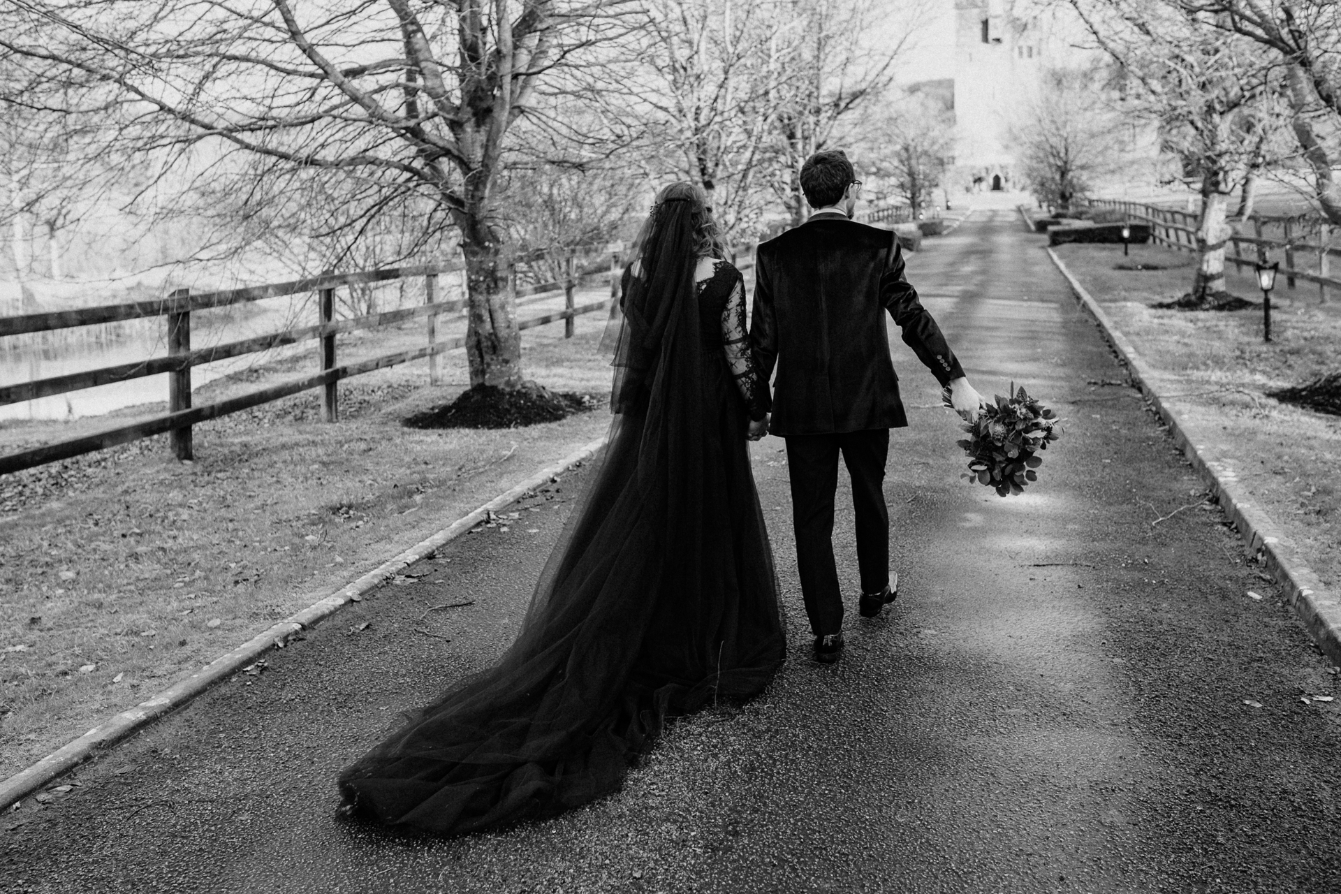 A man and woman walking down a sidewalk in the snow