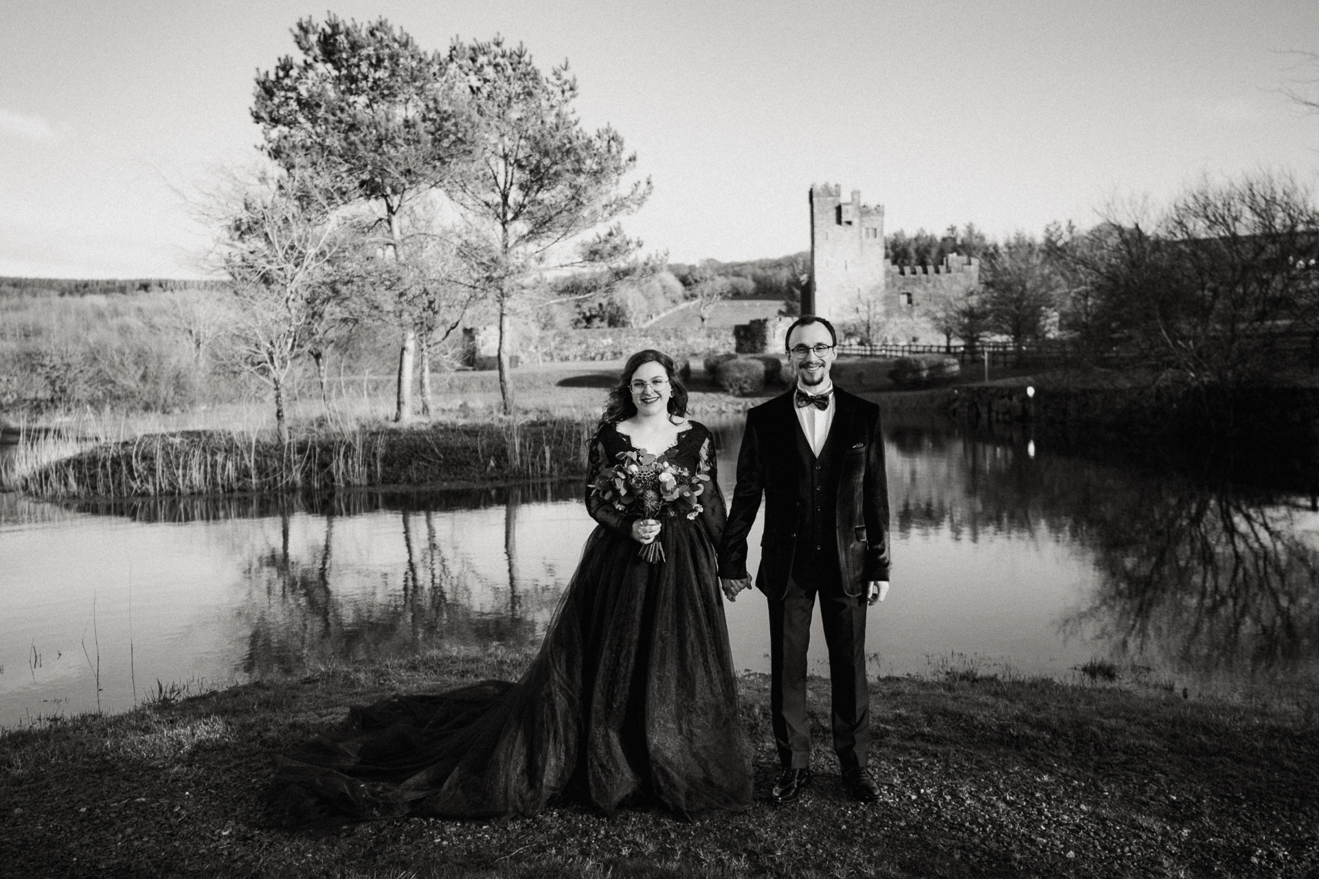 A man and woman posing for a picture next to a pond