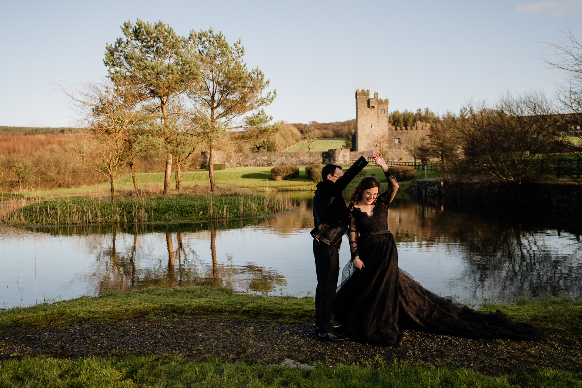 A man and woman posing for a picture next to a pond