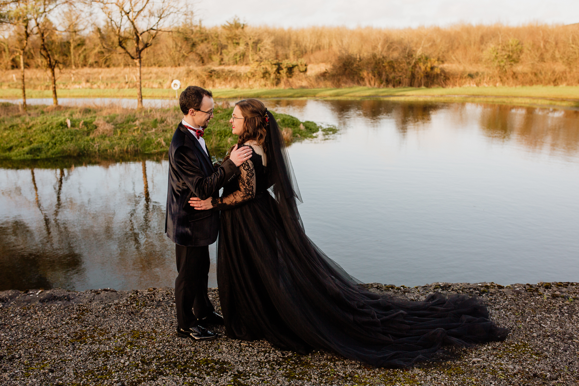 A man and woman kissing by a lake