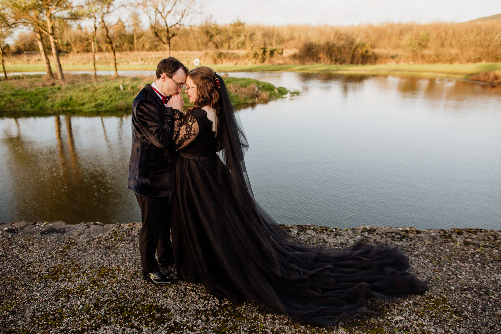 A man and woman kissing by a lake