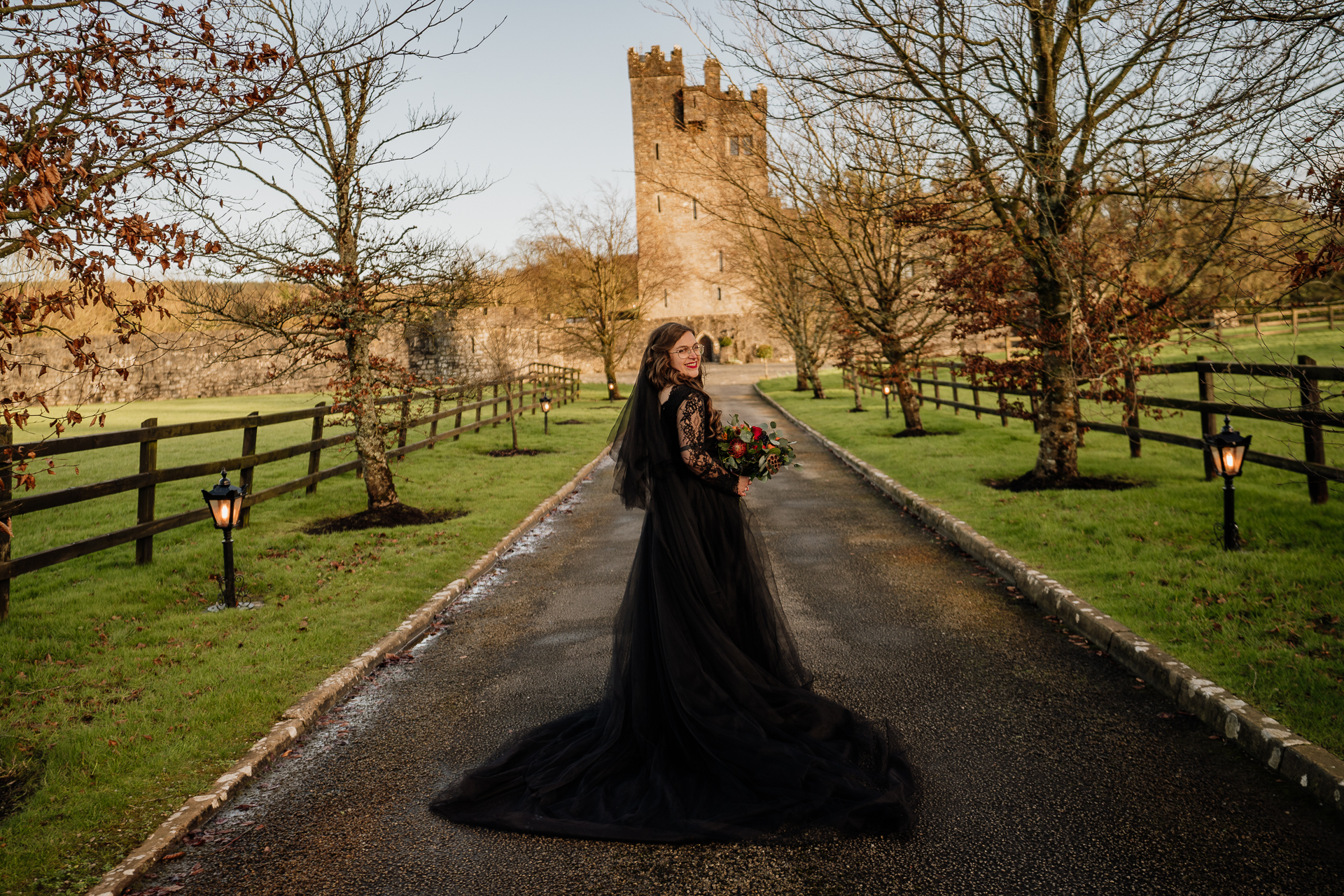 A person in a dress walking down a path with a castle in the background