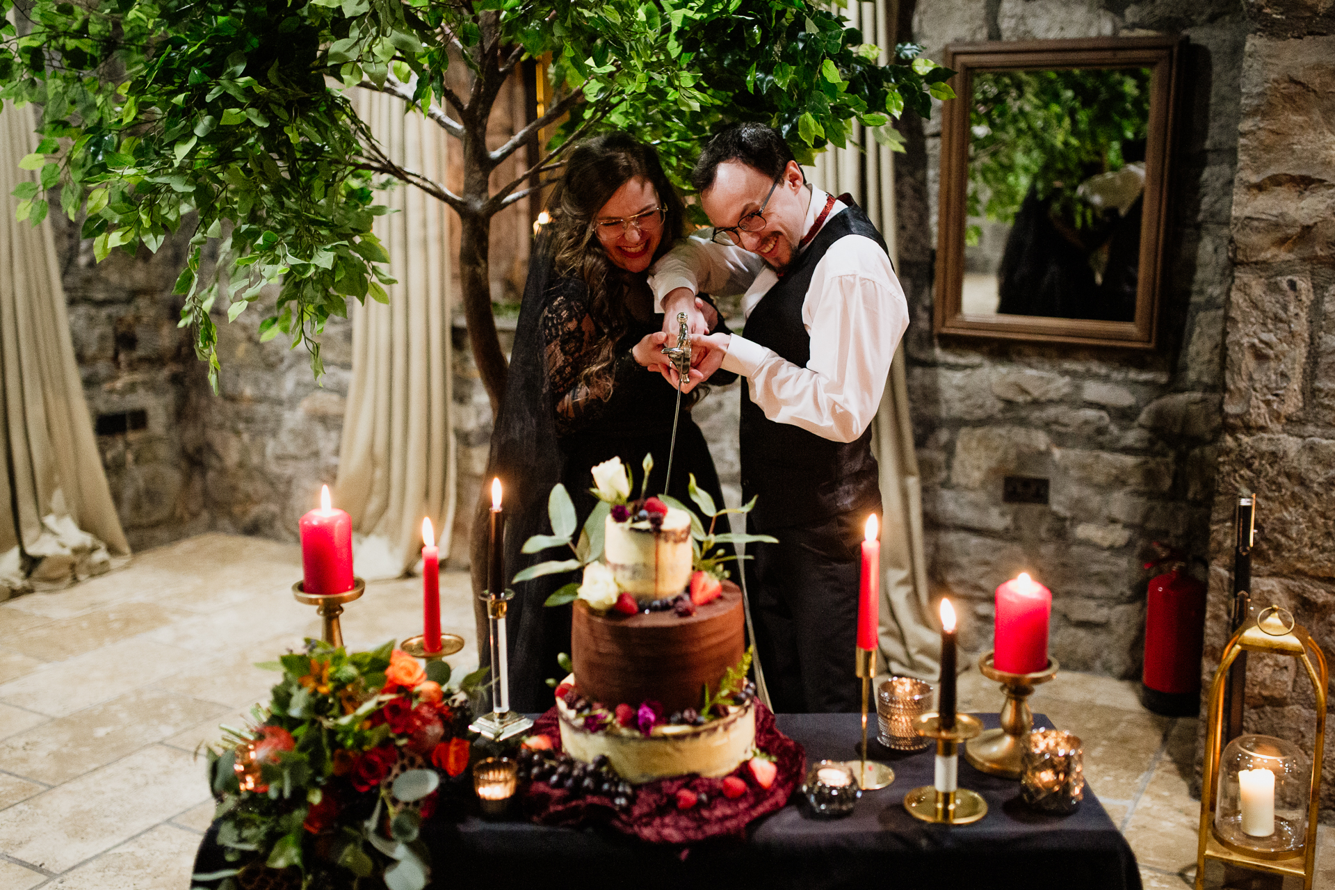 A man and woman kissing in front of a cake with candles