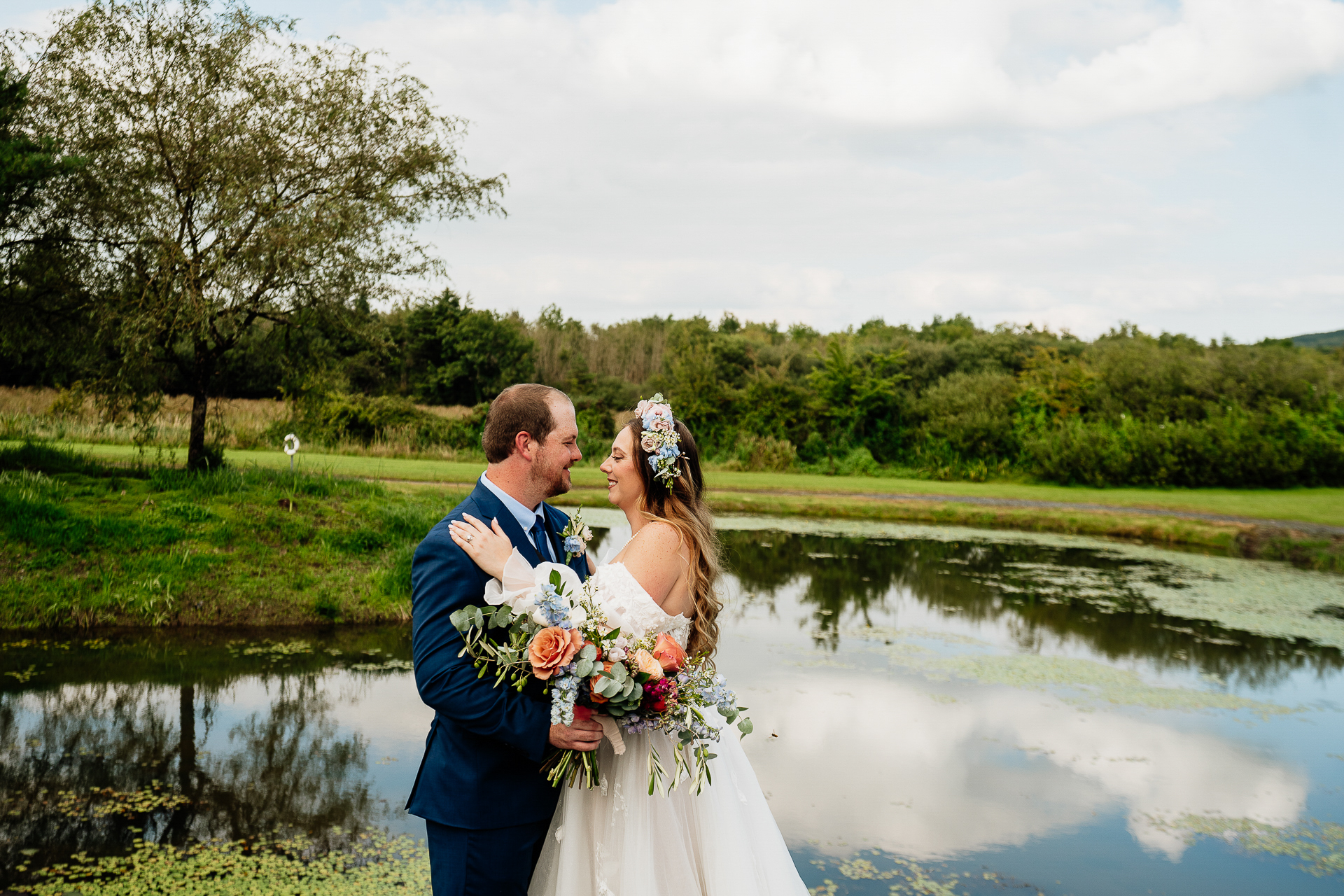 A man and woman kissing by a pond