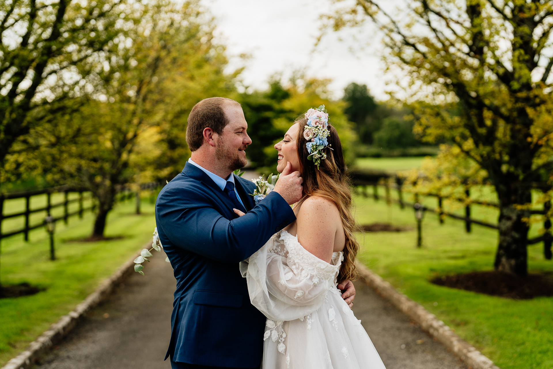 A man and woman kissing on a path in a park