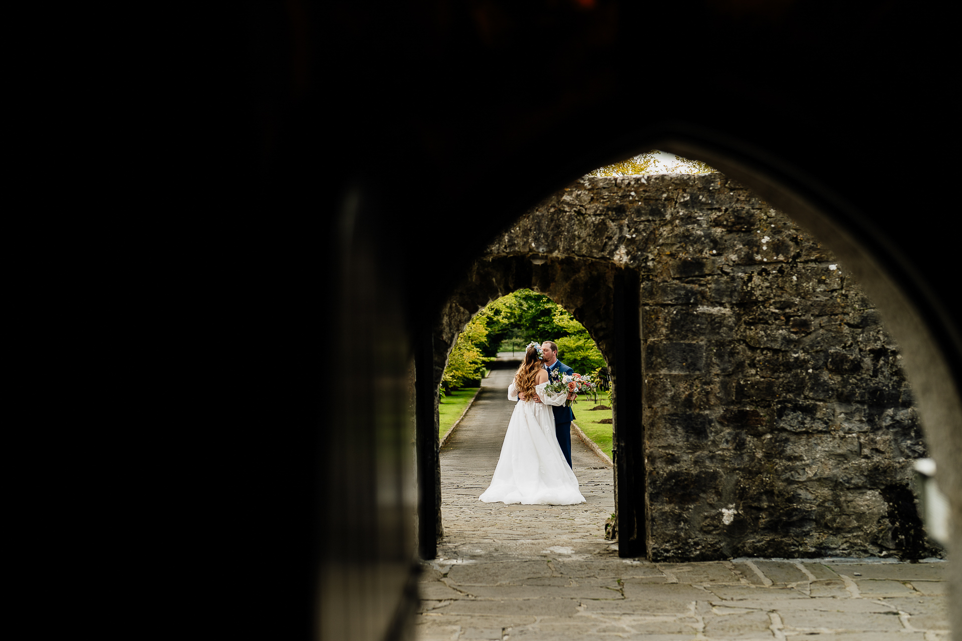 A bride and groom kissing in a tunnel