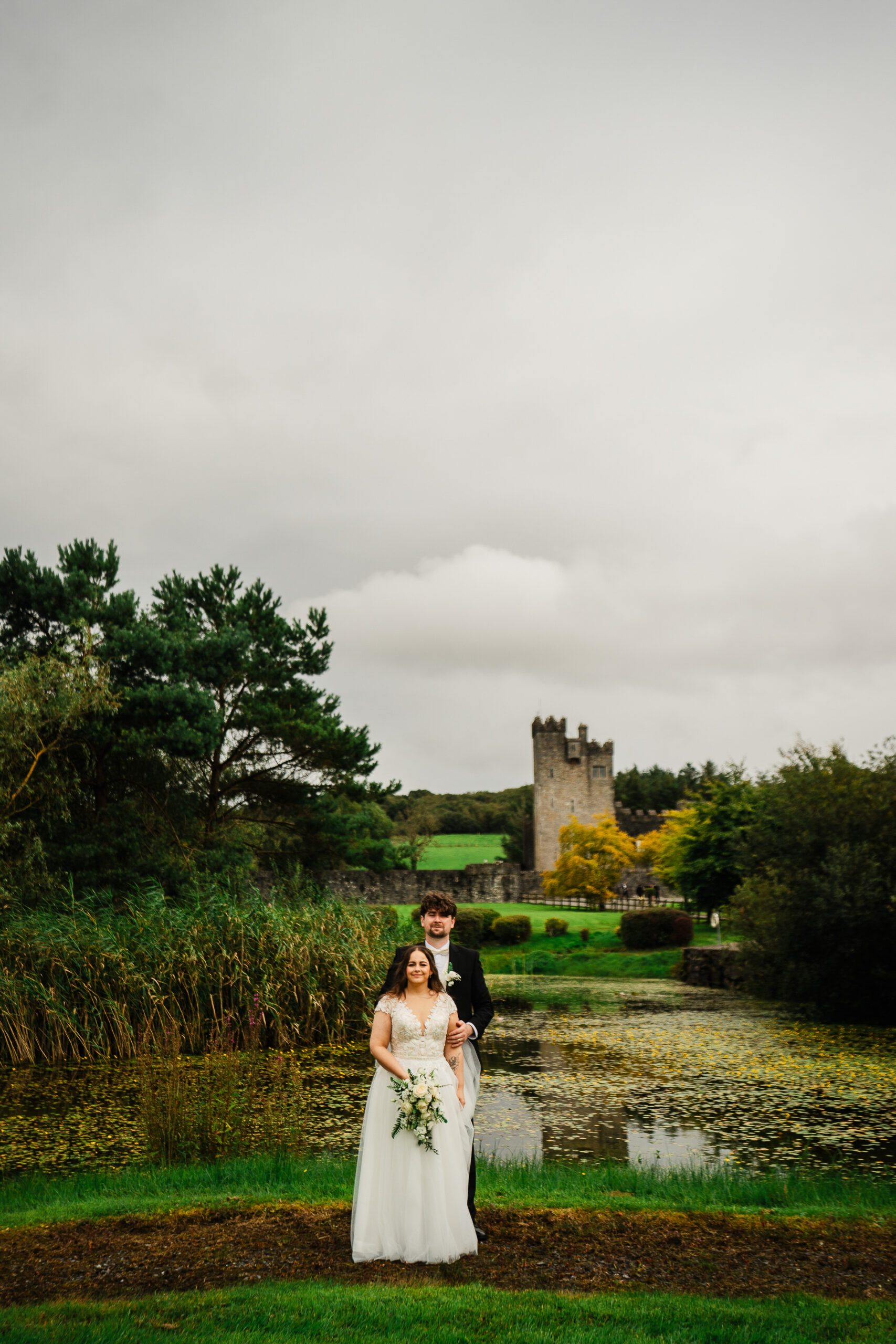 A man and woman posing for a picture in front of a castle