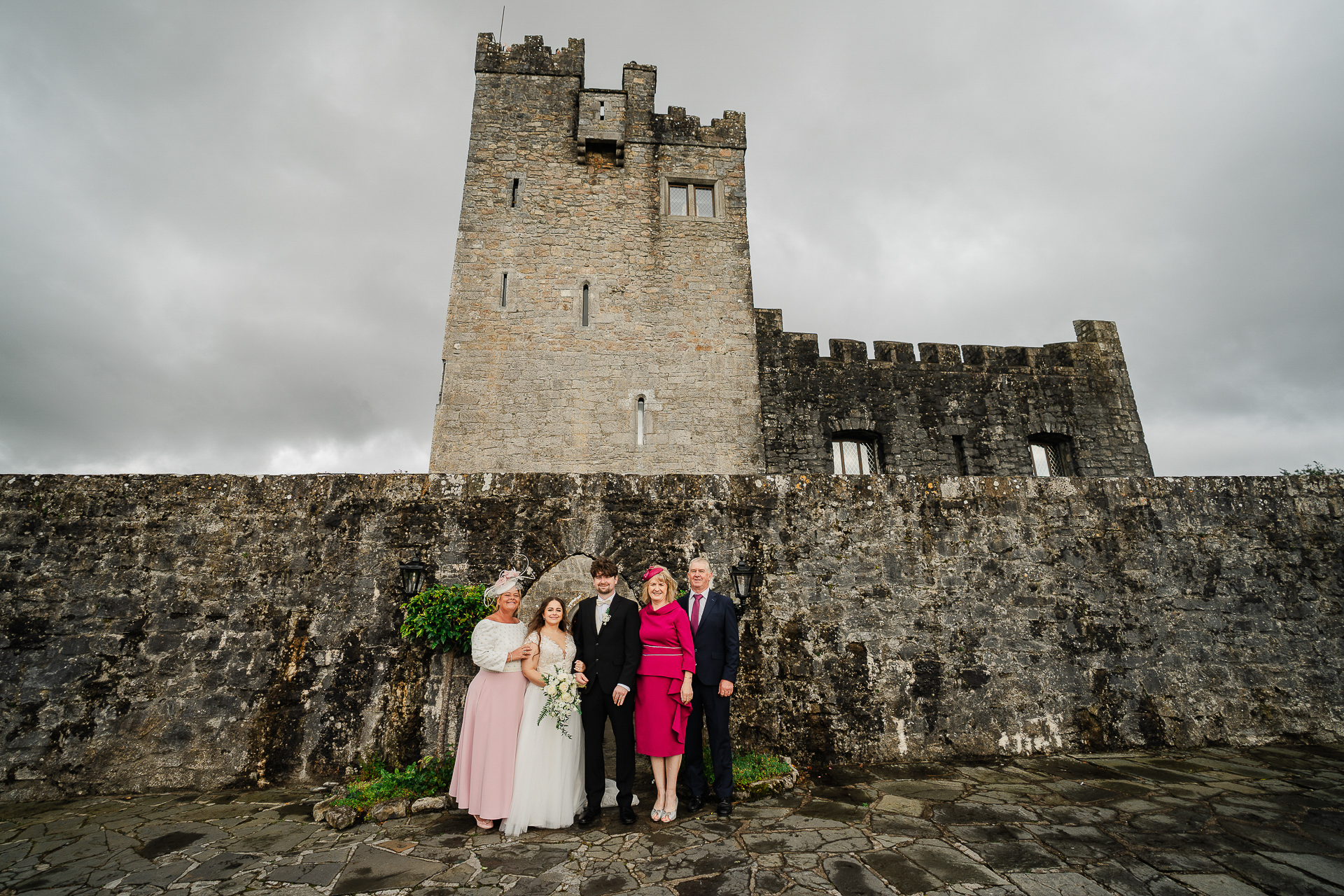 A group of people posing in front of a castle