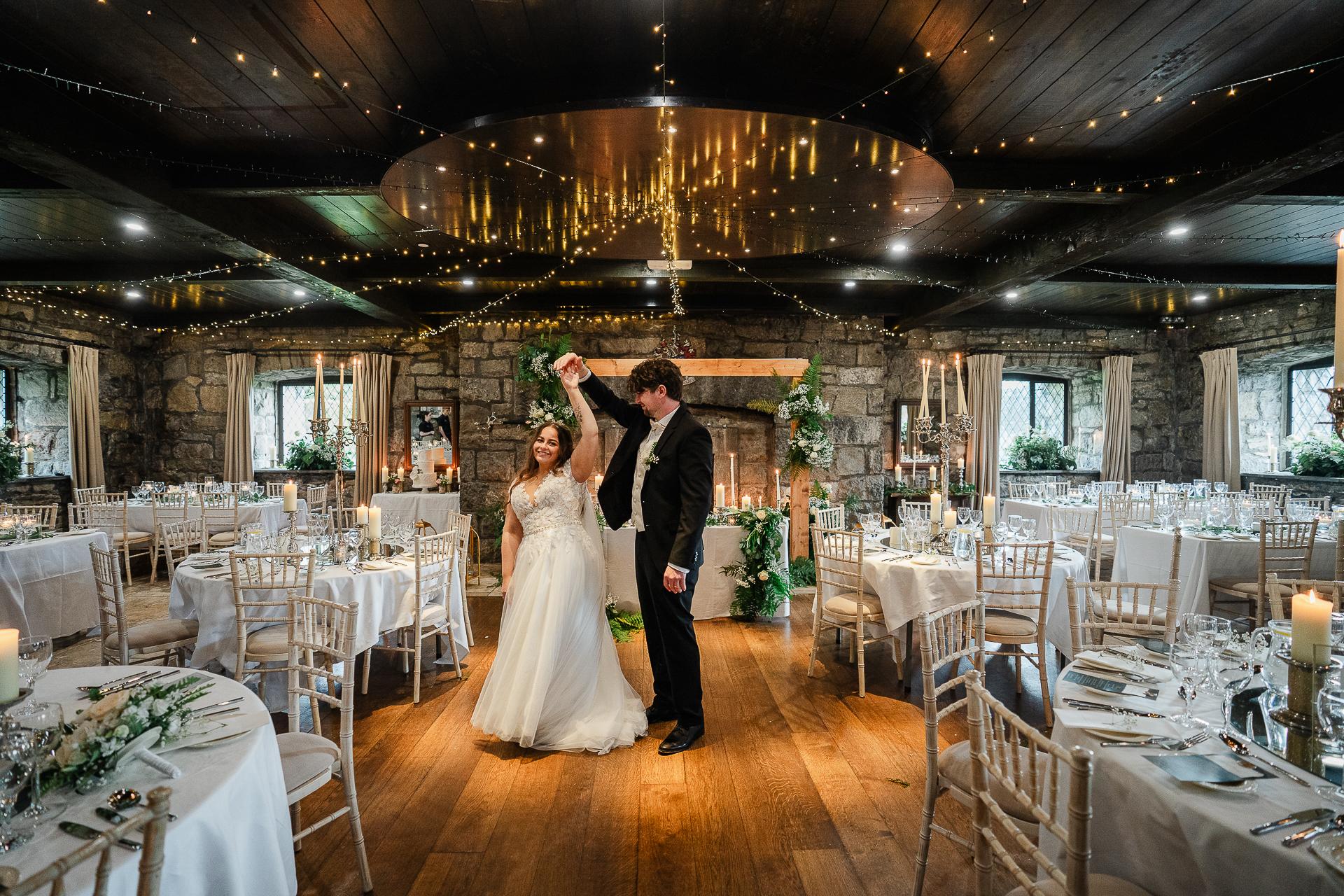 A man and woman dancing in a room with tables and chairs