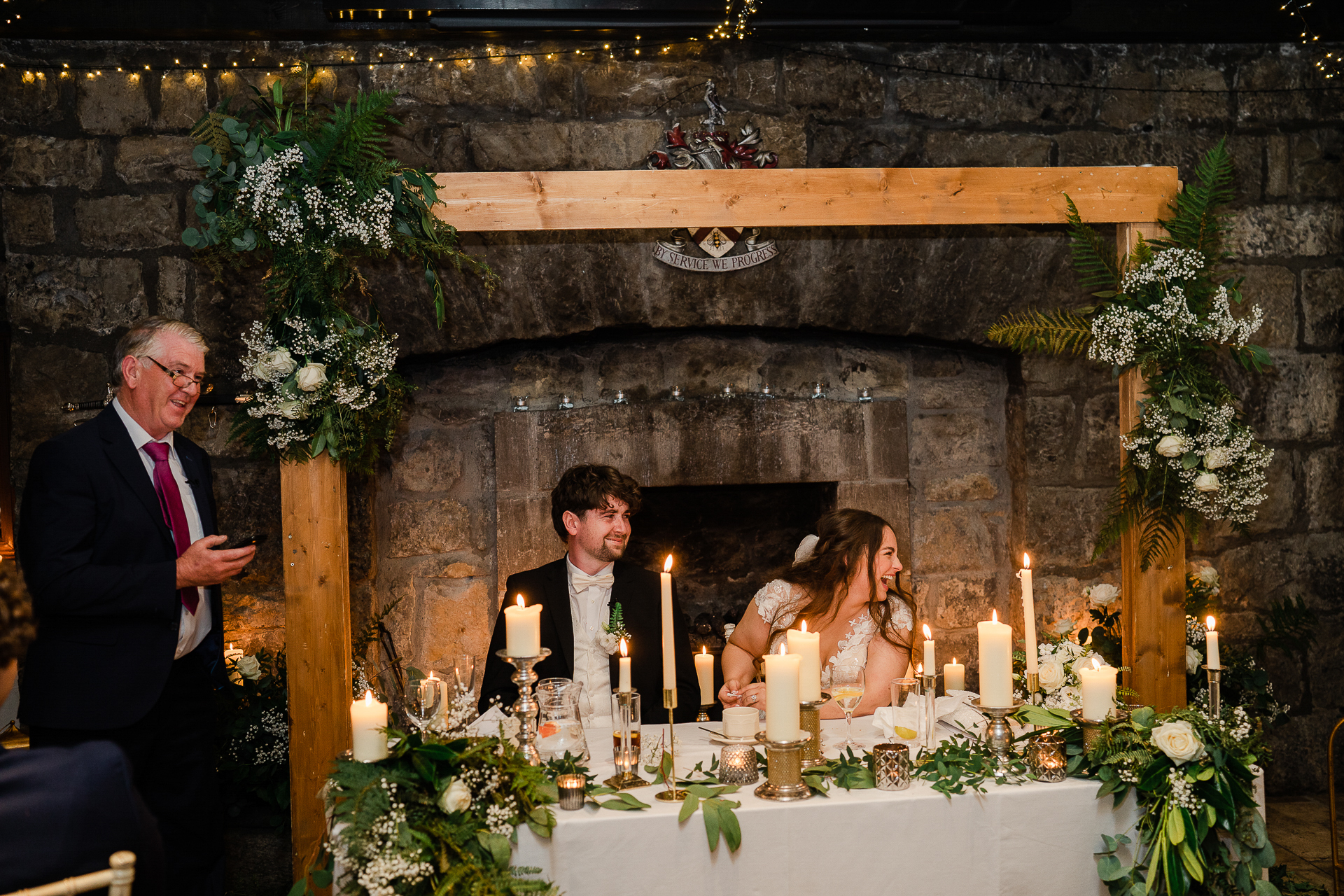 A man and woman standing next to a table with candles and flowers