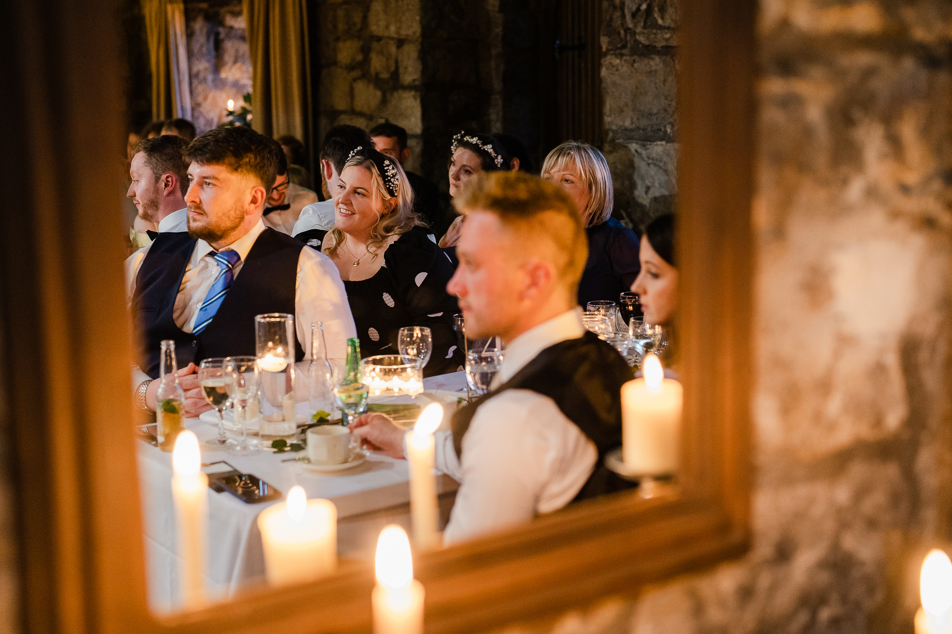 A group of people sitting at a table with wine glasses and candles