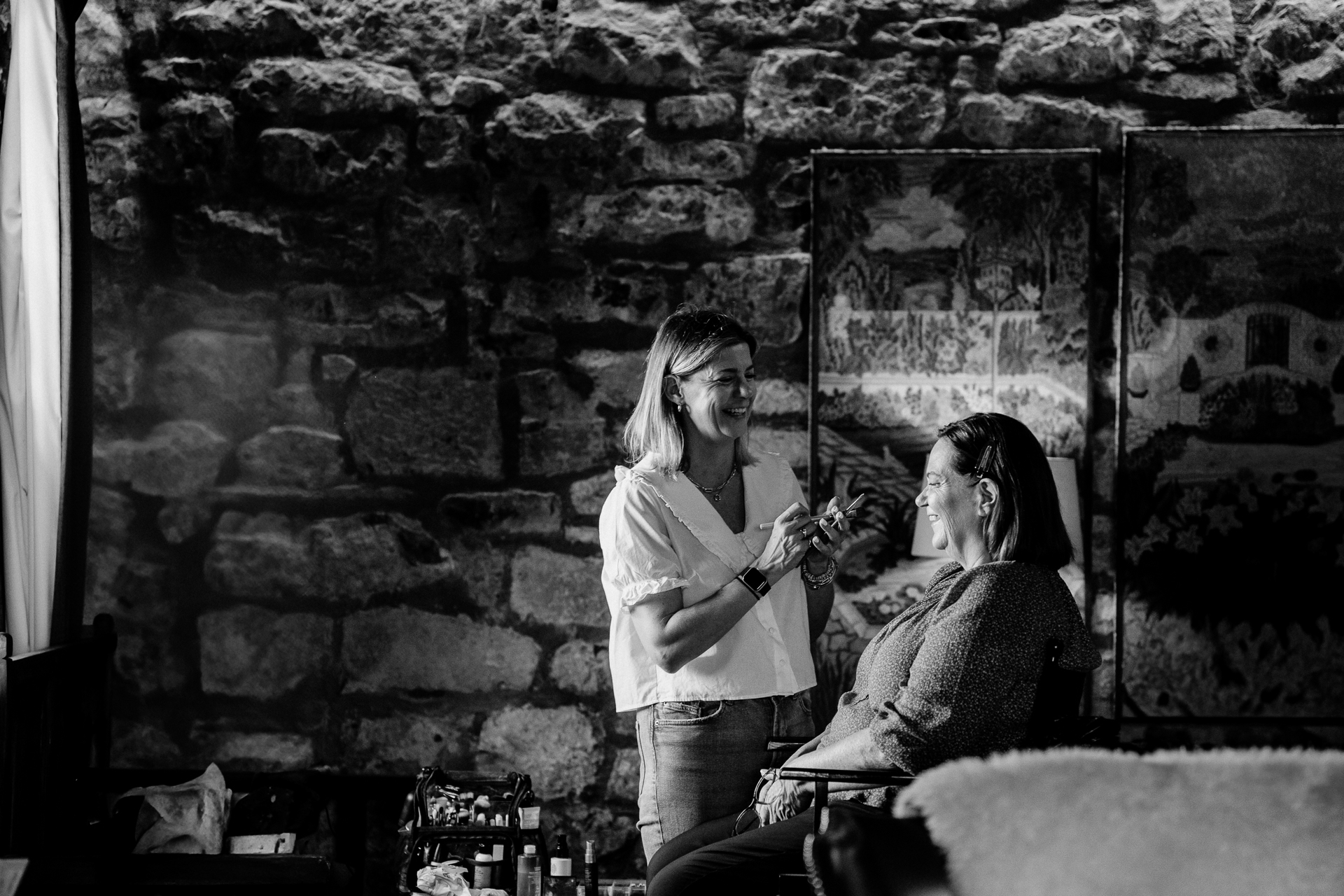 A woman cutting another woman's hair