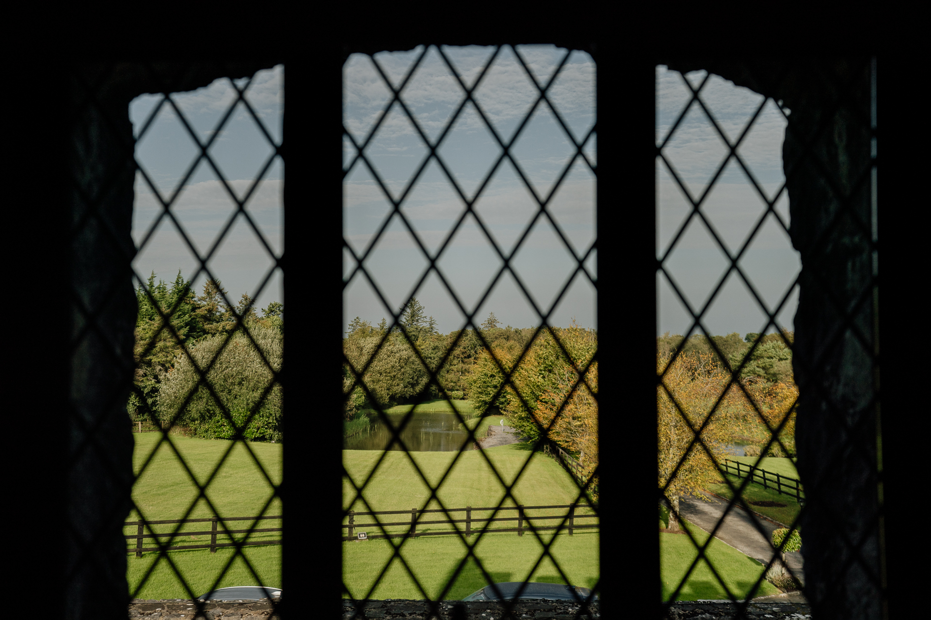 A view through a gate of a house and trees