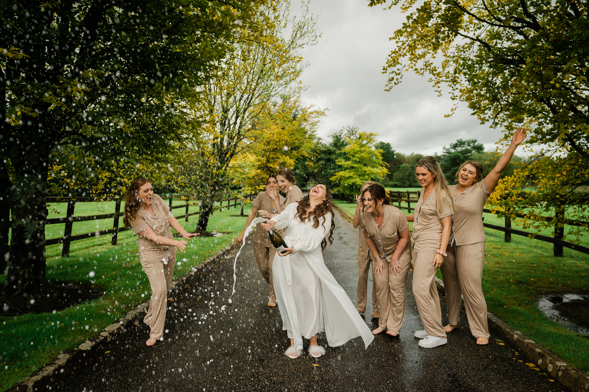 A group of women walking down a path with a man in a white dress and a woman in