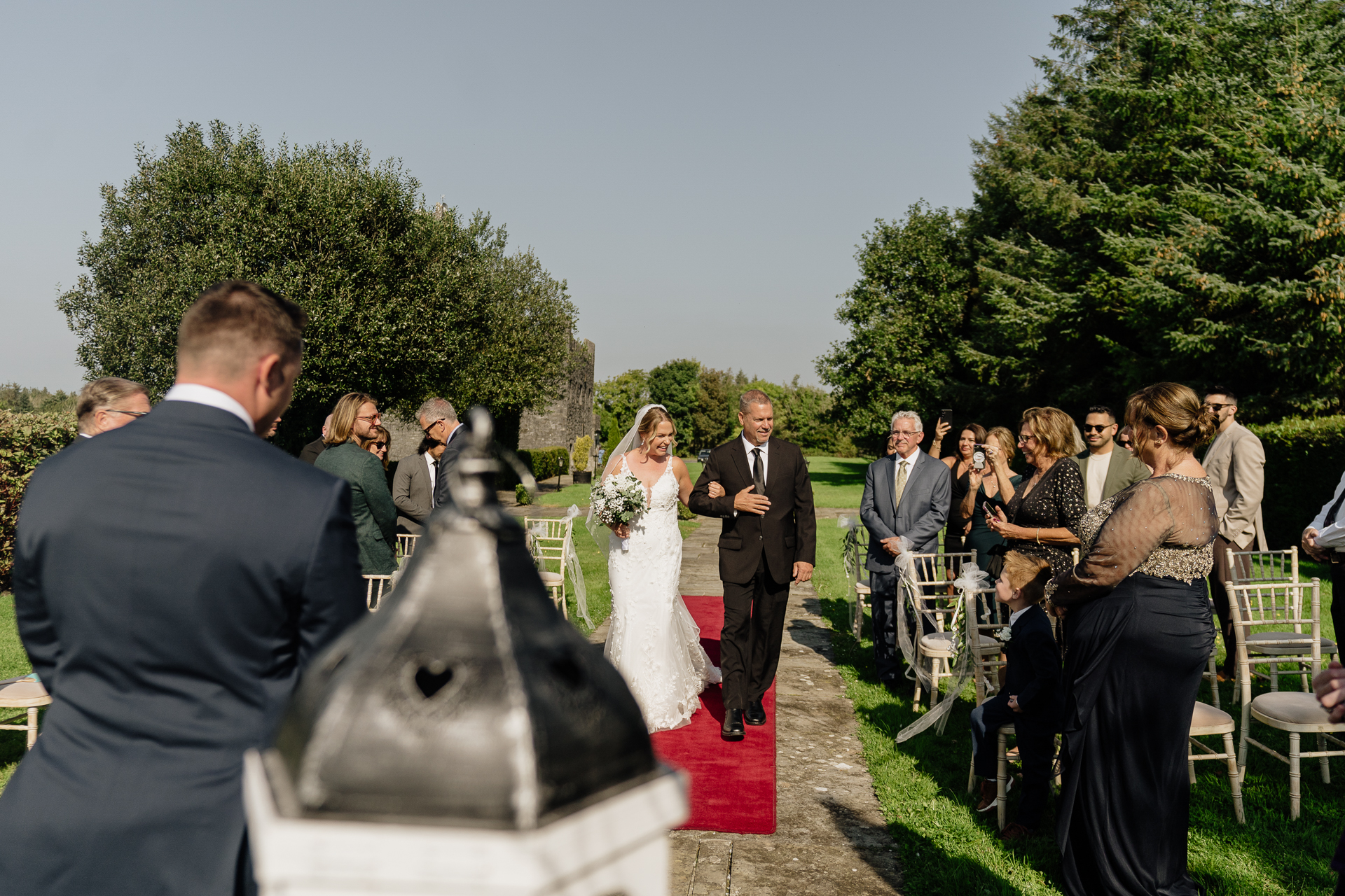 A man and woman walking down a red carpet with a crowd watching