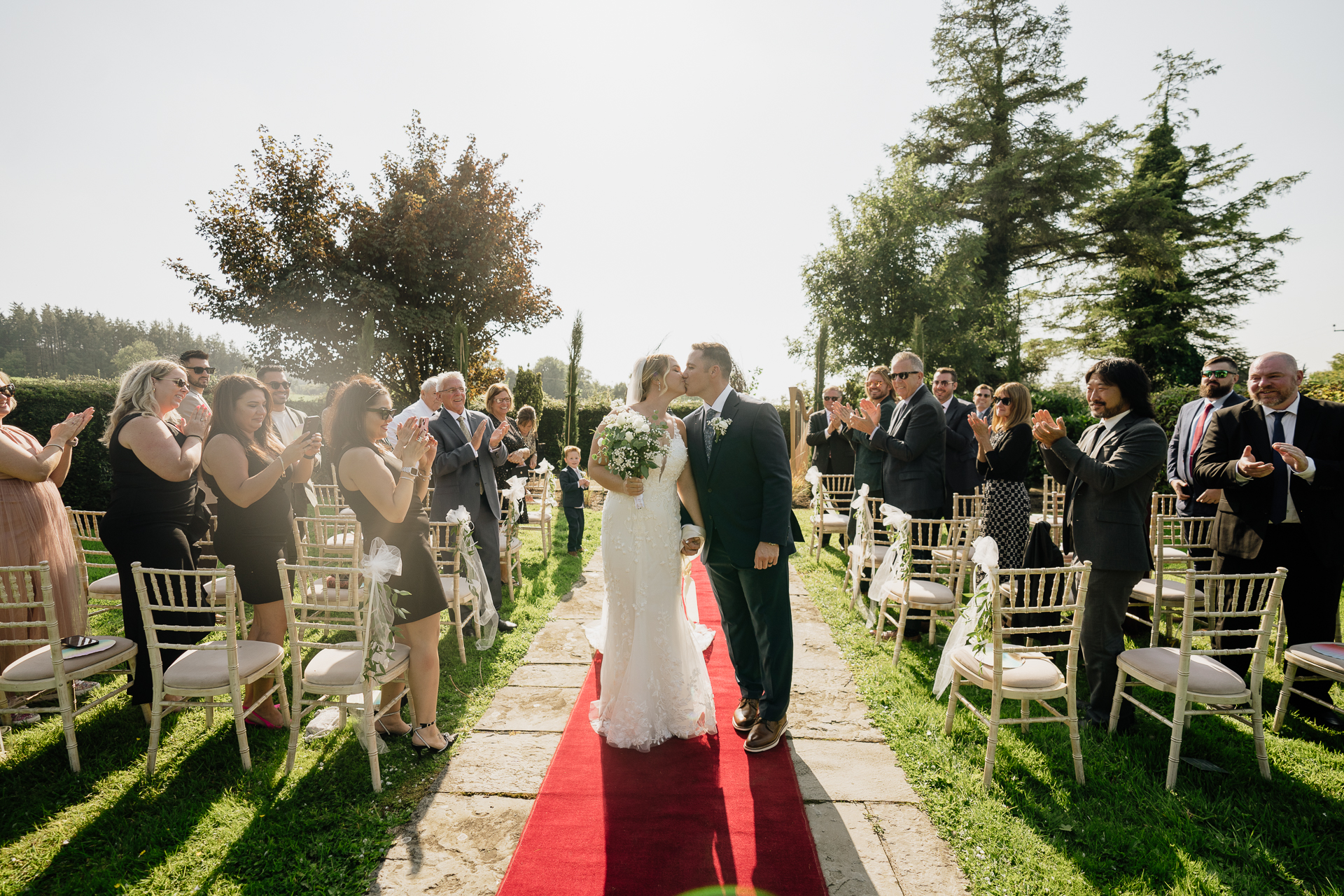 A man and woman walking down a aisle with a group of people watching