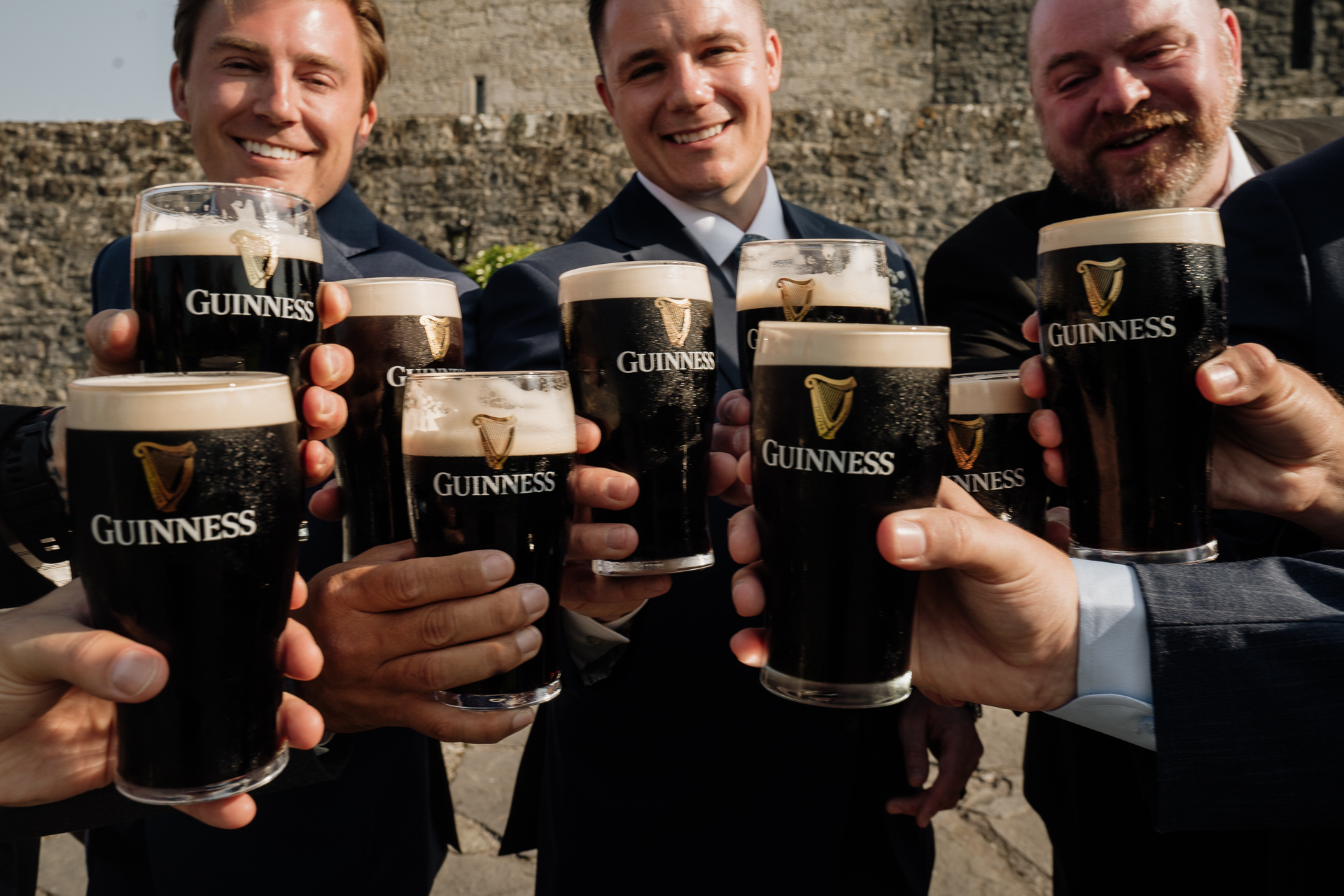 A group of men holding up glasses of beer