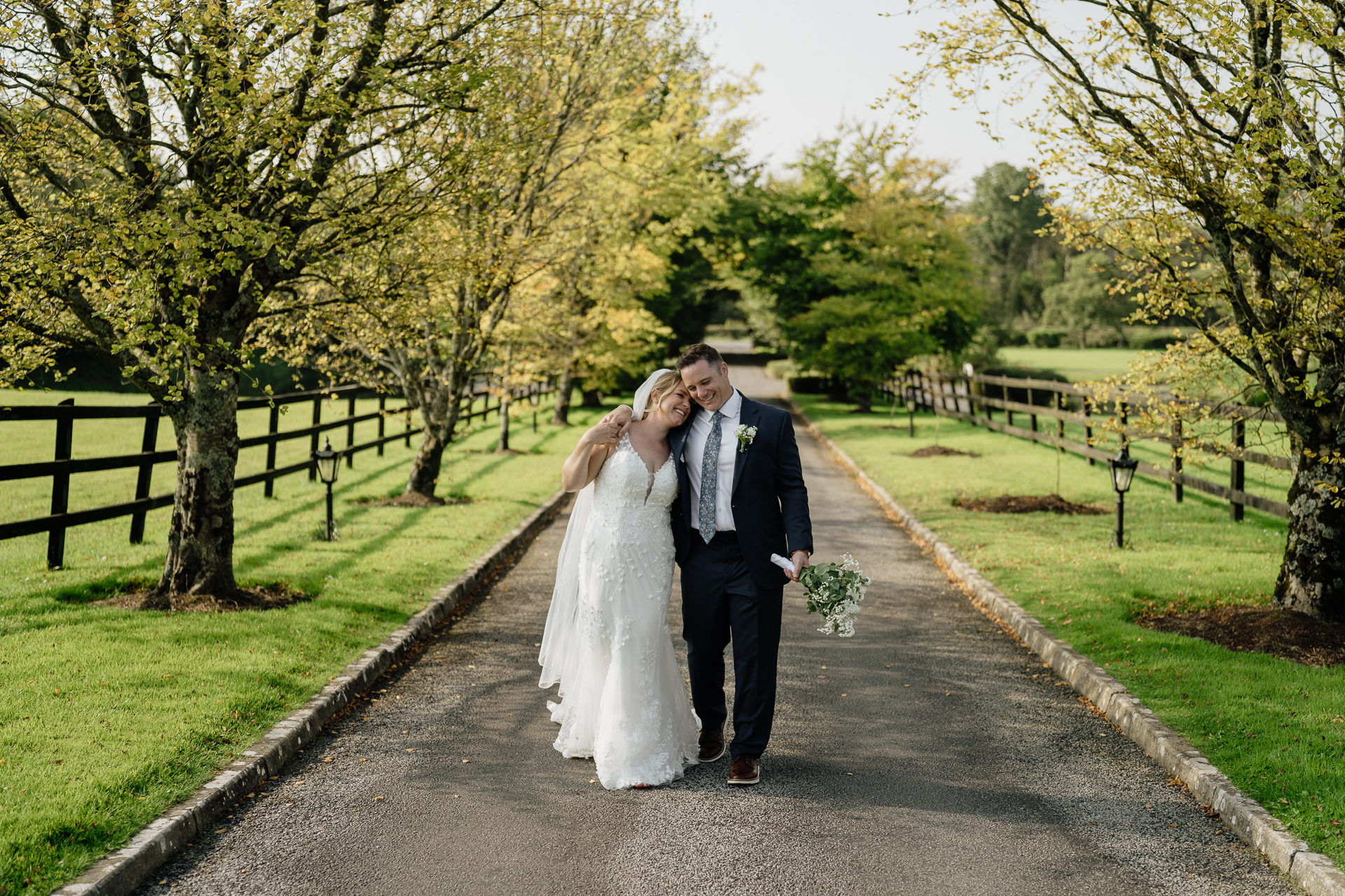 A man and woman kissing on a path in a park