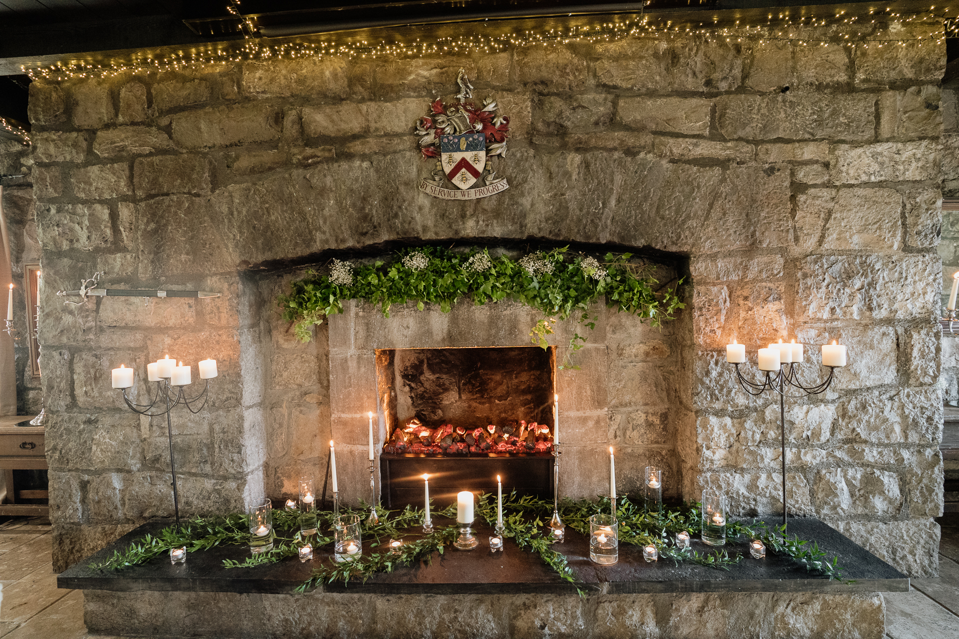 A fireplace with candles and flowers