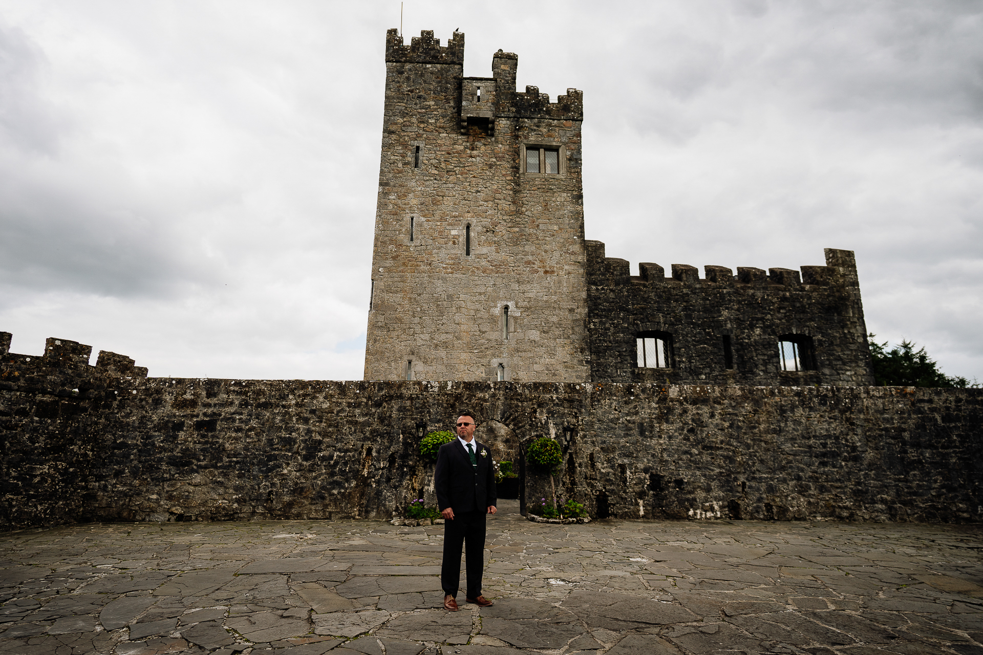 A person standing in front of a stone castle