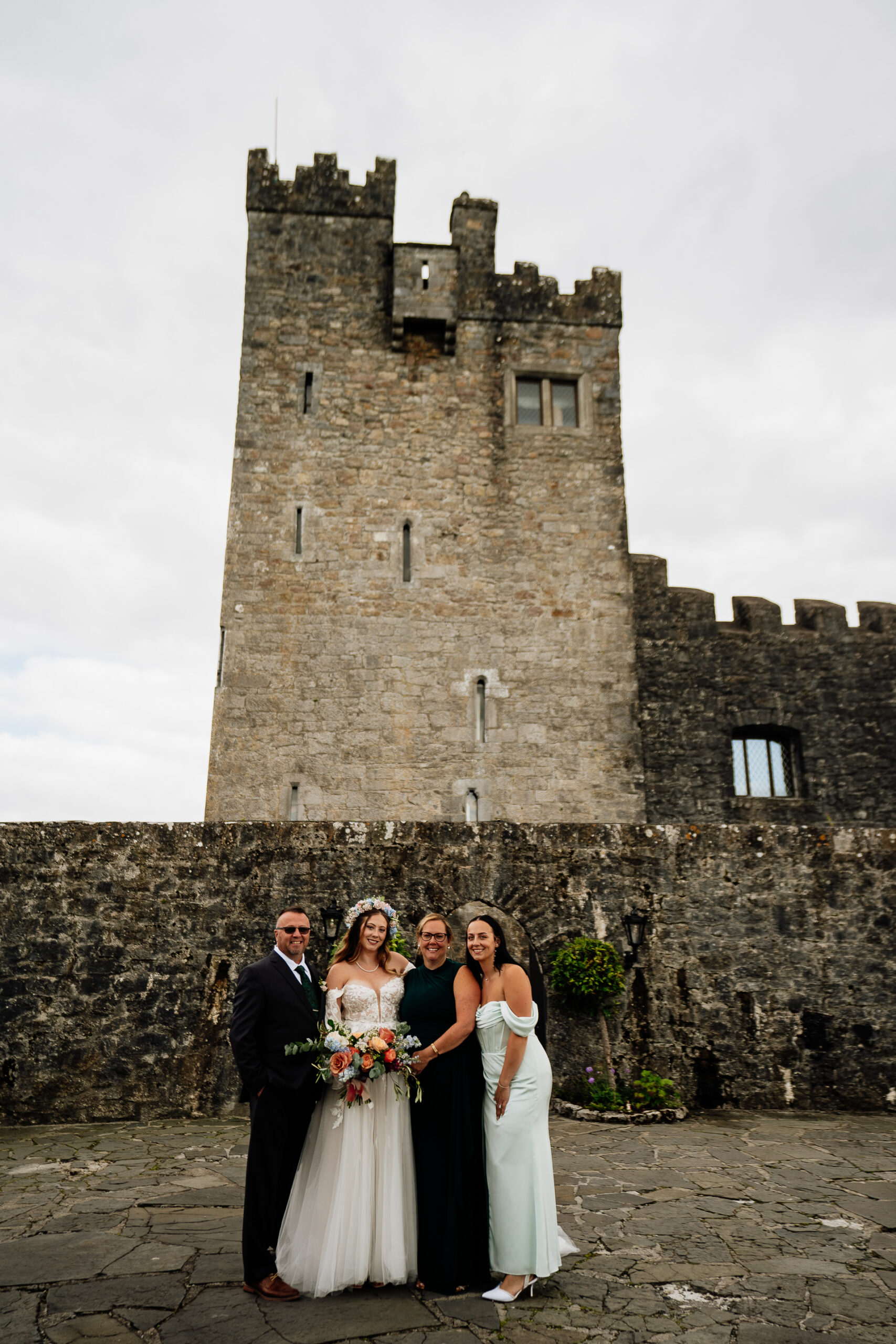 A group of people posing for a photo in front of a castle