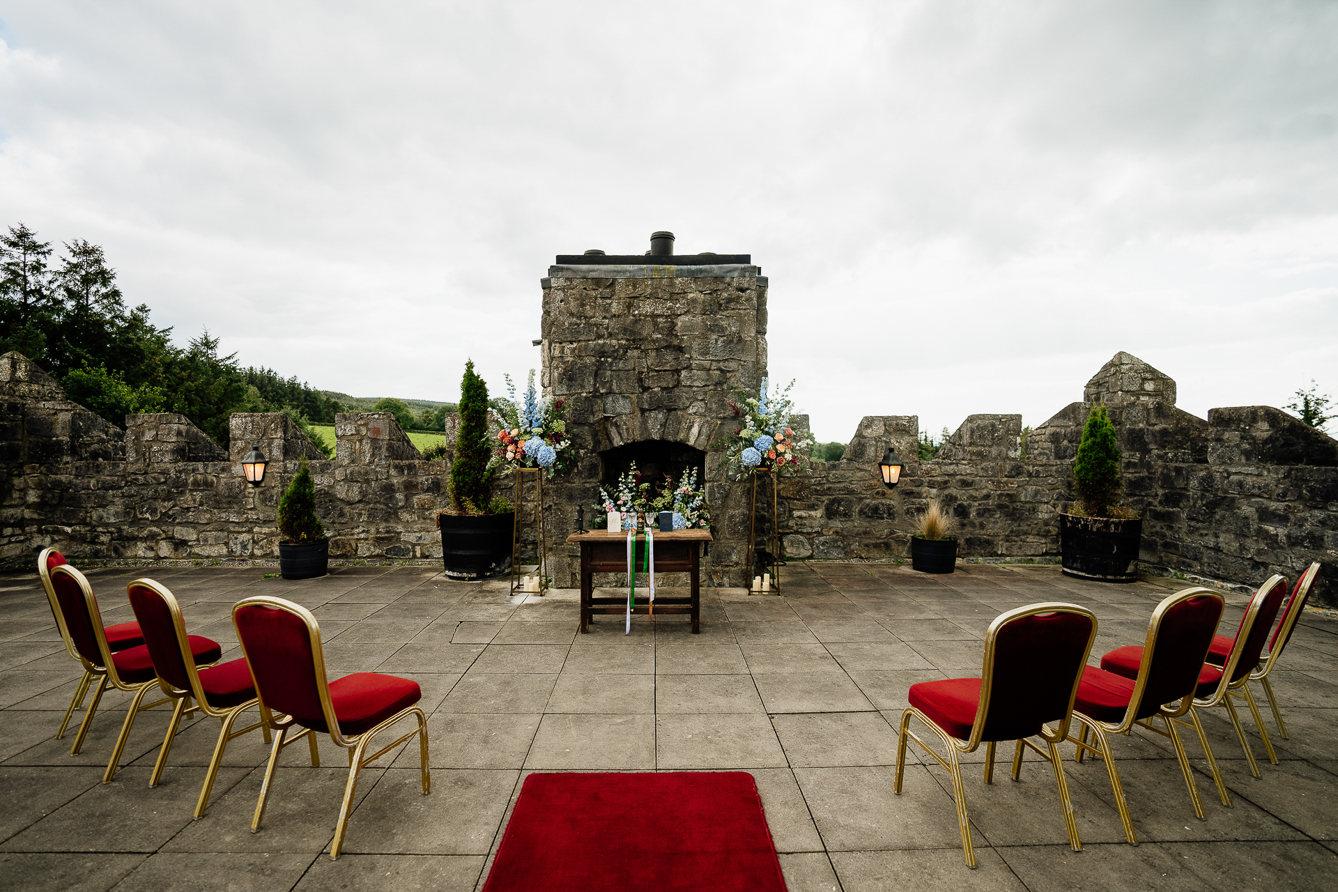 A patio with chairs and a table with a fireplace in the background