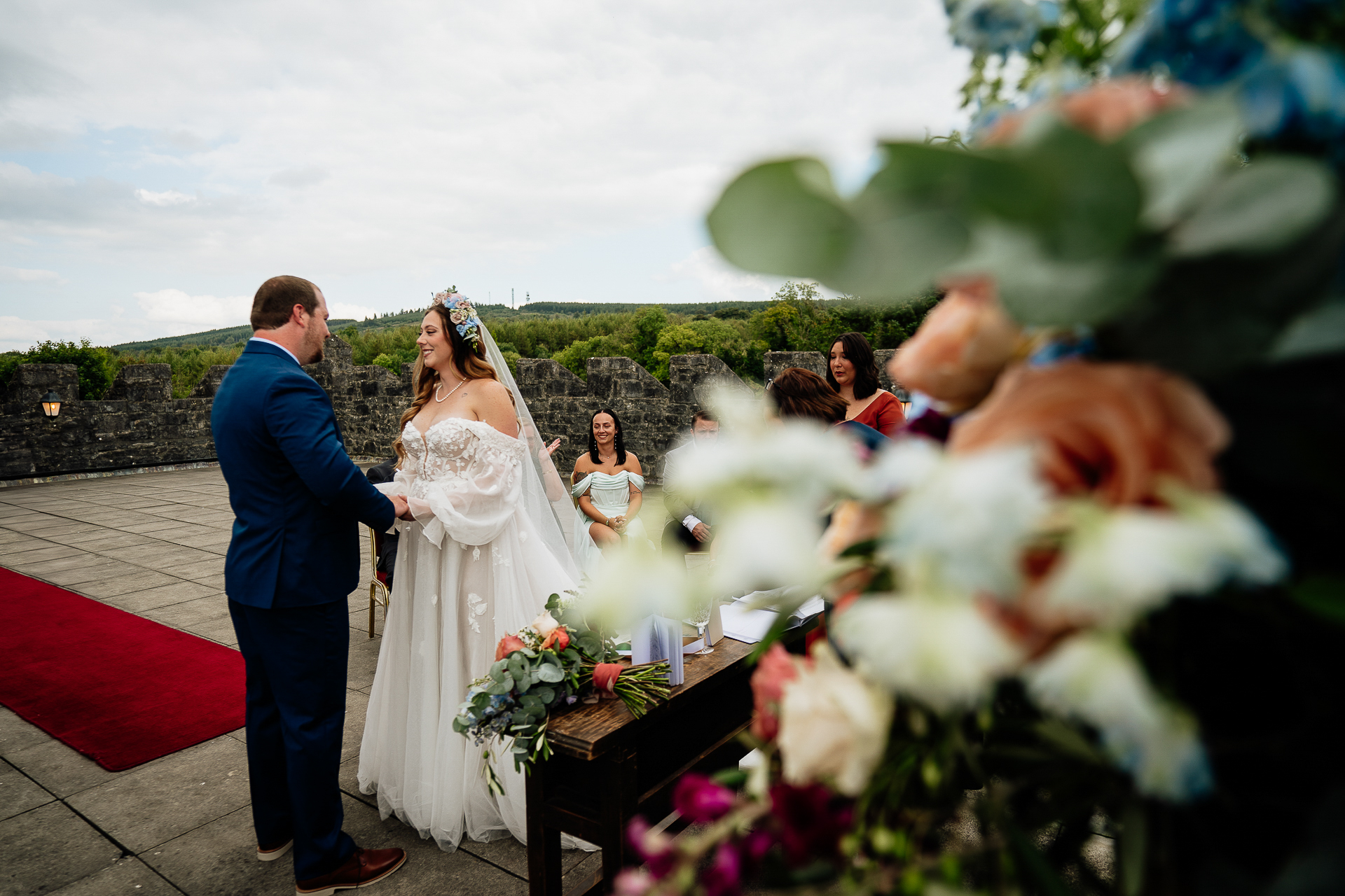 A man and woman walking down a sidewalk with a bouquet of flowers