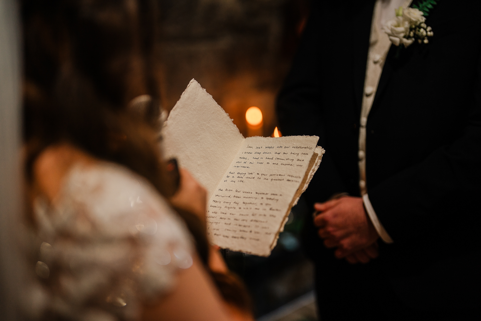 A person holding a paper with a candle in the background