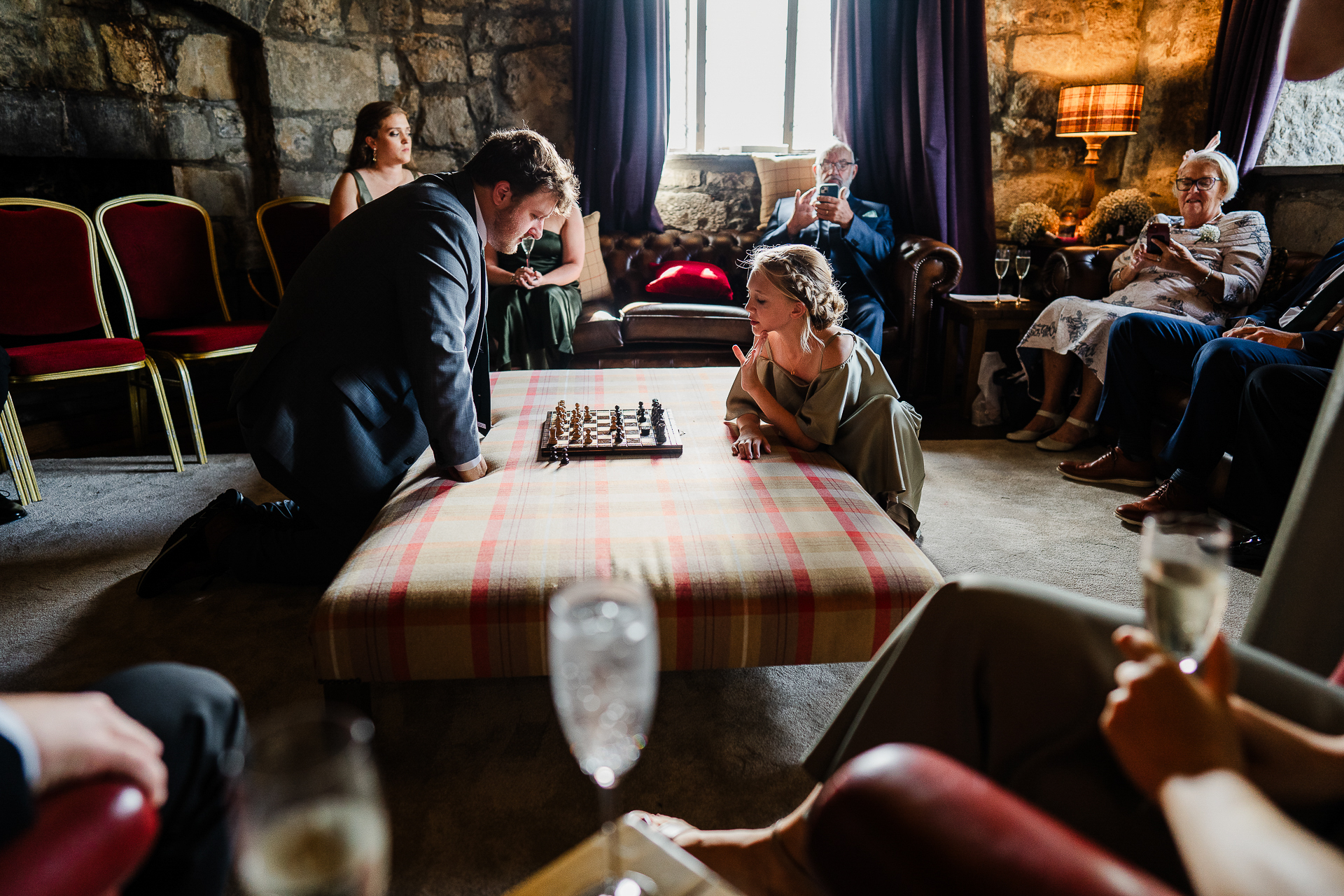 A group of people sitting around a table playing chess