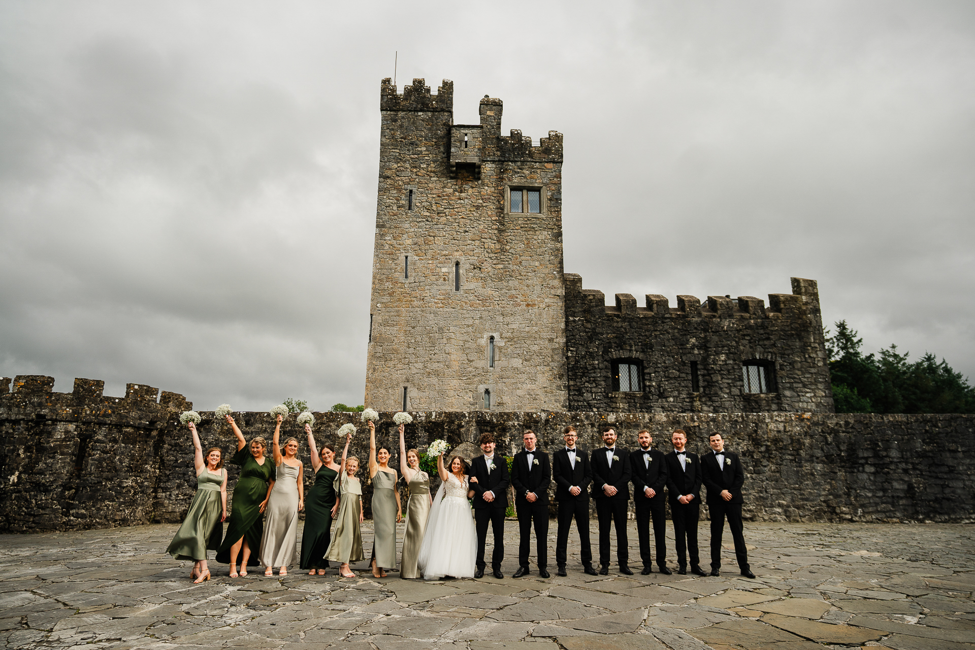 A group of people posing for a photo in front of a castle